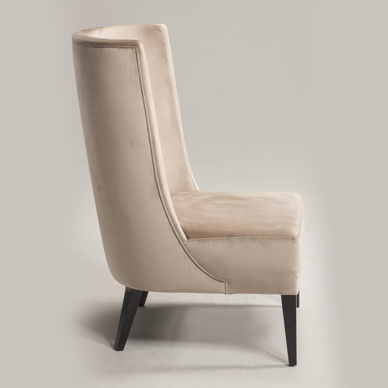 This elegant armchair boasts a sleek silhouette, defined by a curved back and no armrests. Upholstered in luxuriously soft velvety fabric, its understated yet refined design is supported by four tapered feet. With its versatile beige tone, the