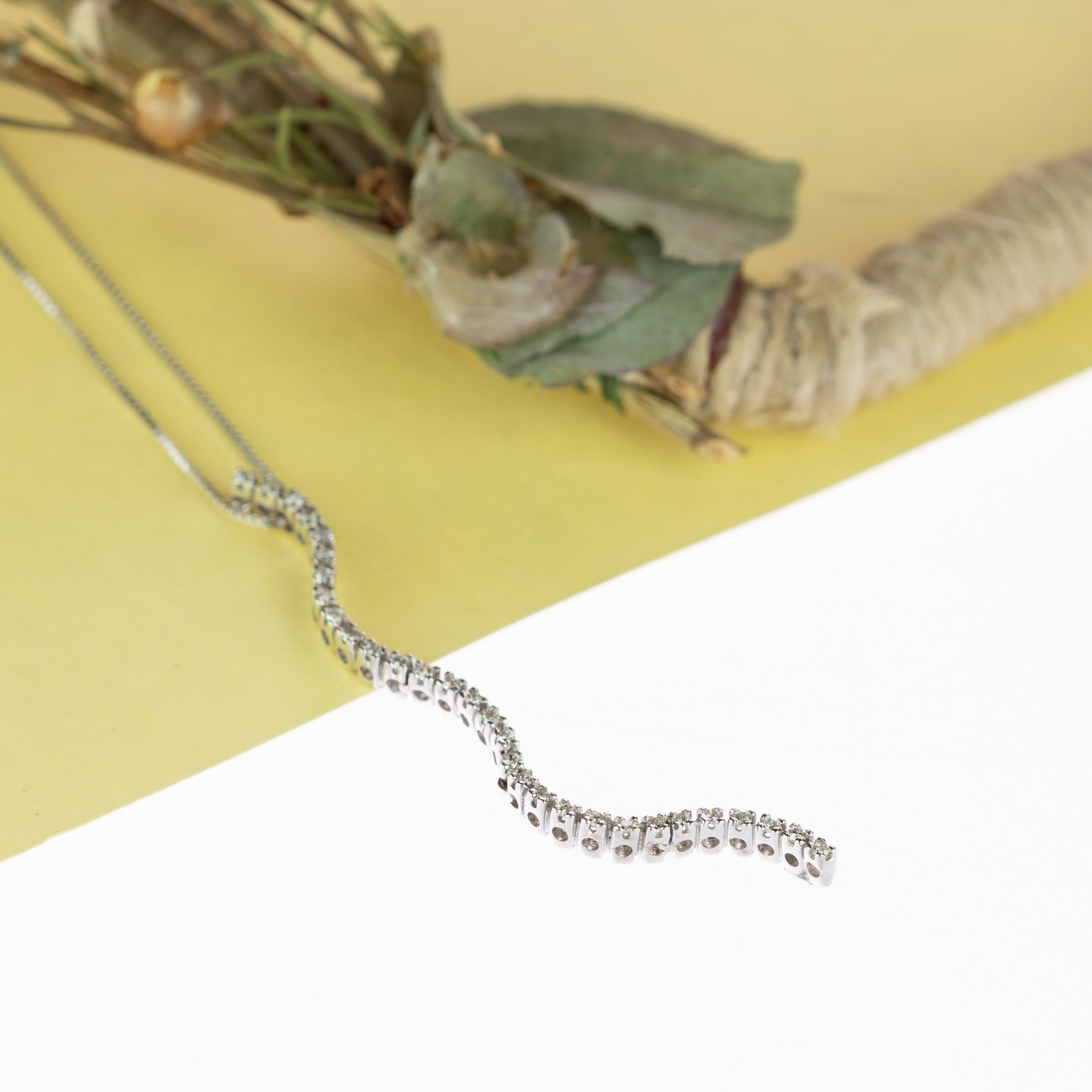 Stunning and marvelous curved vertical bar diamond pendant embellished with a delicate 41.5 cm 18k white gold chain. A total of 0.32 carat diamonds create a snake / serpent shape of gems to decorate a clear chest and give a fancy, clean and luxury