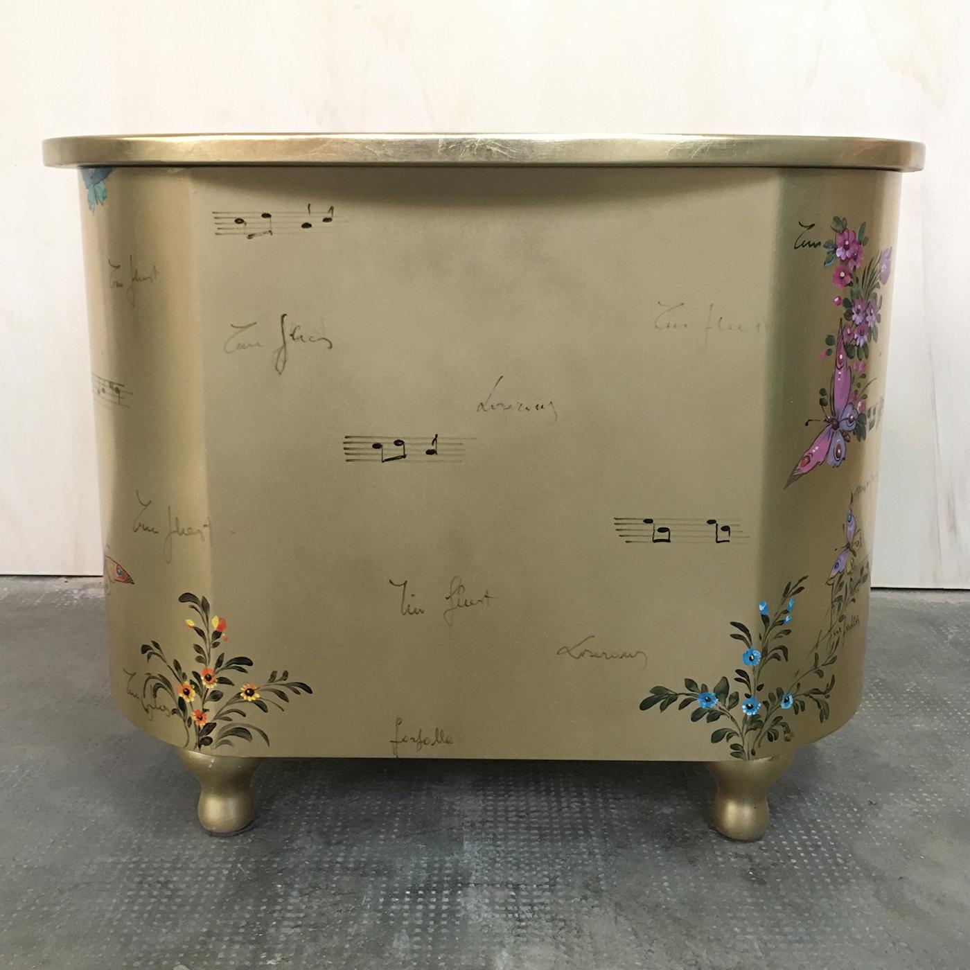 A curved bedside table covered with a gold leaf and with delicious paintings of flowers, butterflies and music by an art master. It has a laminated wood structure with 3 drawers and 2 secrets. Inside the decorated book, the customer can enter his