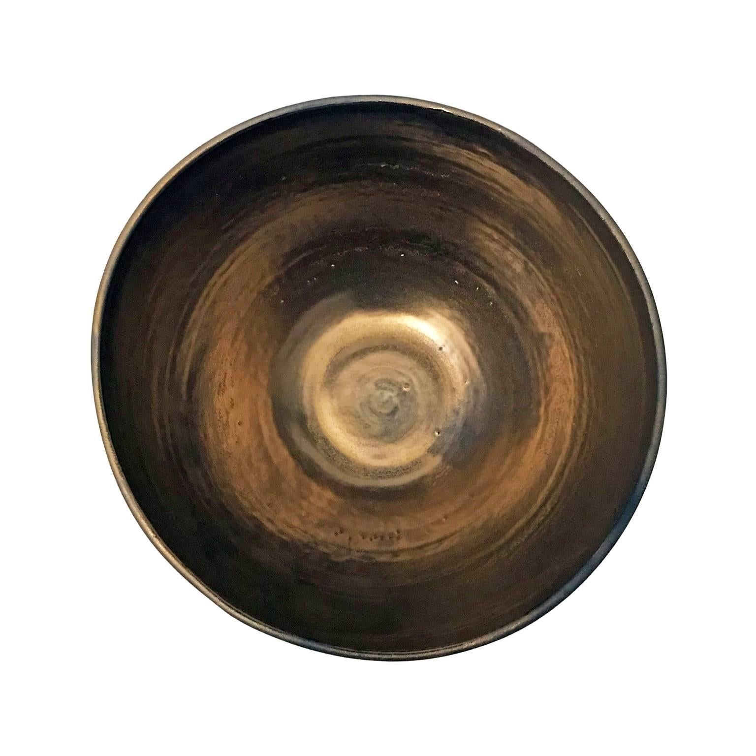 Curved black ceramic bowl with gold glaze interior by Sandi Fellman, USA, 2018.

Veteran photographer Sandi Fellman's ceramic vessels are an exploration of a new medium. The forms, palettes, and sensuality of her photos can be found within each