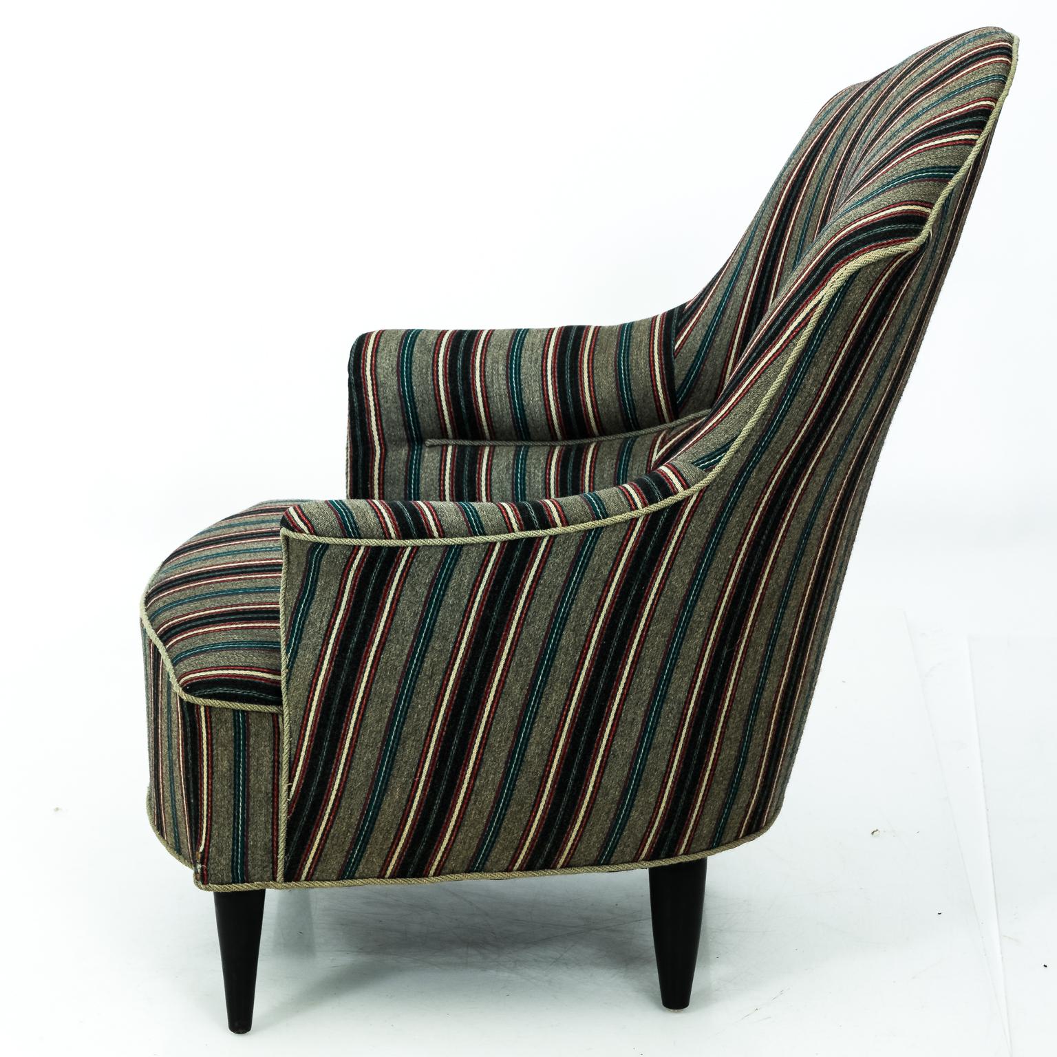 Curved back slipper chair with woolen striped upholstery on black painted legs, circa 1970s.
 