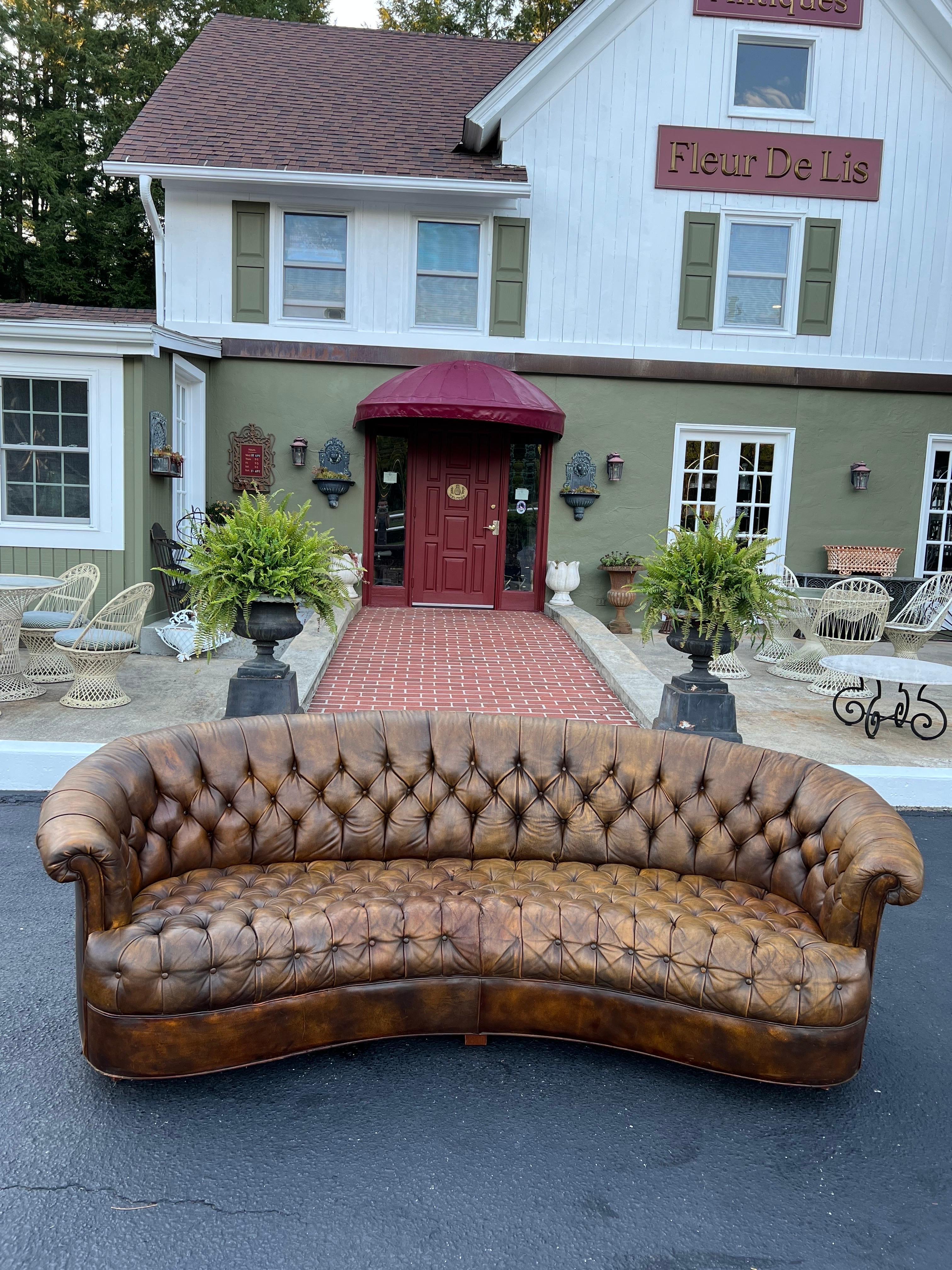 Curved brown leather Chesterfield sofa. The perfect amount of wear and patina on this classic beauty. Please inquire about our local or tri state delivery. We can also get you a UShip quote if a zip code is provided.