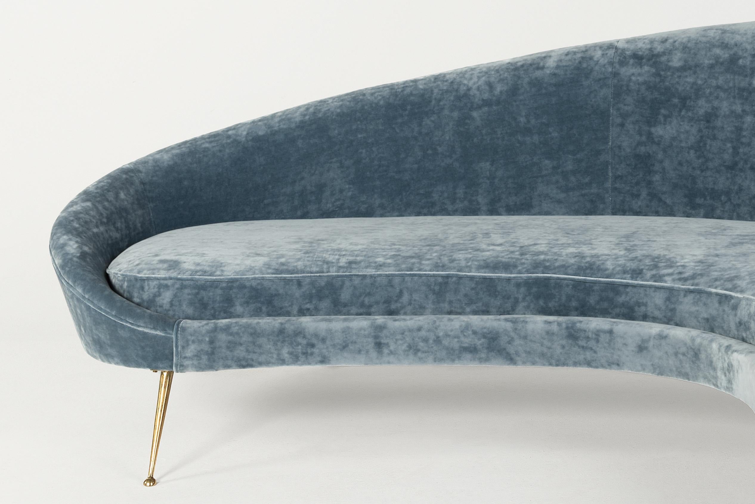 Elegant Italian Mid Century blue velvet sofa in the style of Ico Parisi. Brass Upholstered in blue velvet and featuring brass feet. Ico Parisi`s `Comma` sofa is the 20th Century Design classic . The sofa is newly upholstered in velvet and it's in a