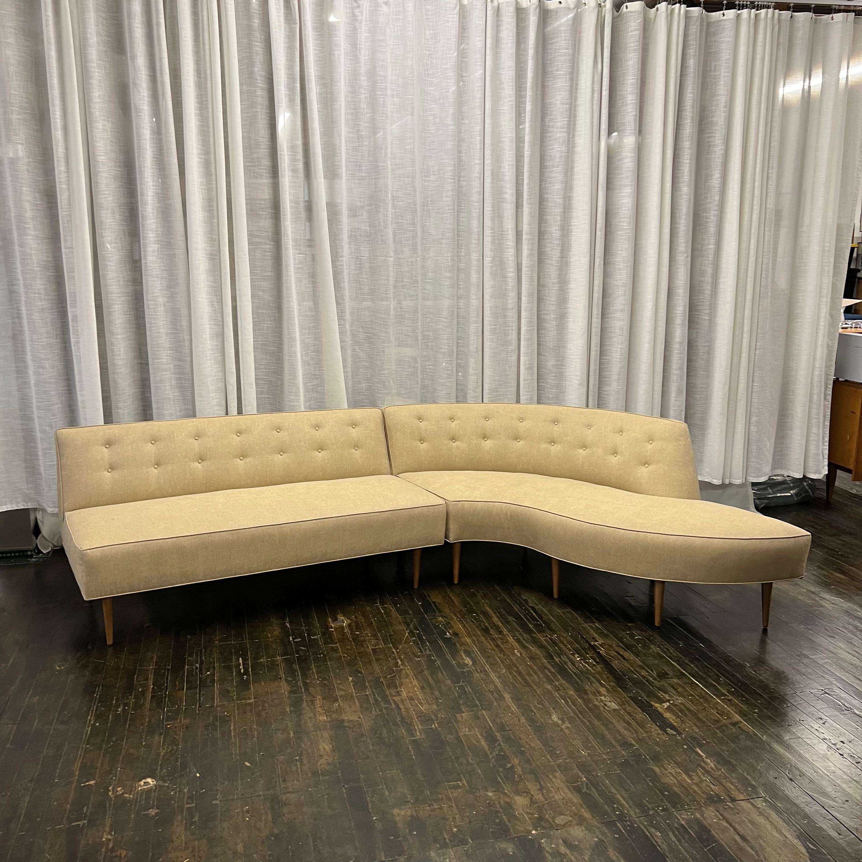 Gorgeous fully restored and reupholstered two piece mid-century curved sectional sofa.  The fitted back has button tufting and it features a tight seat.  It looks lean and sexy.  It is also very comfortable. 

This extraordinary sectional was custom