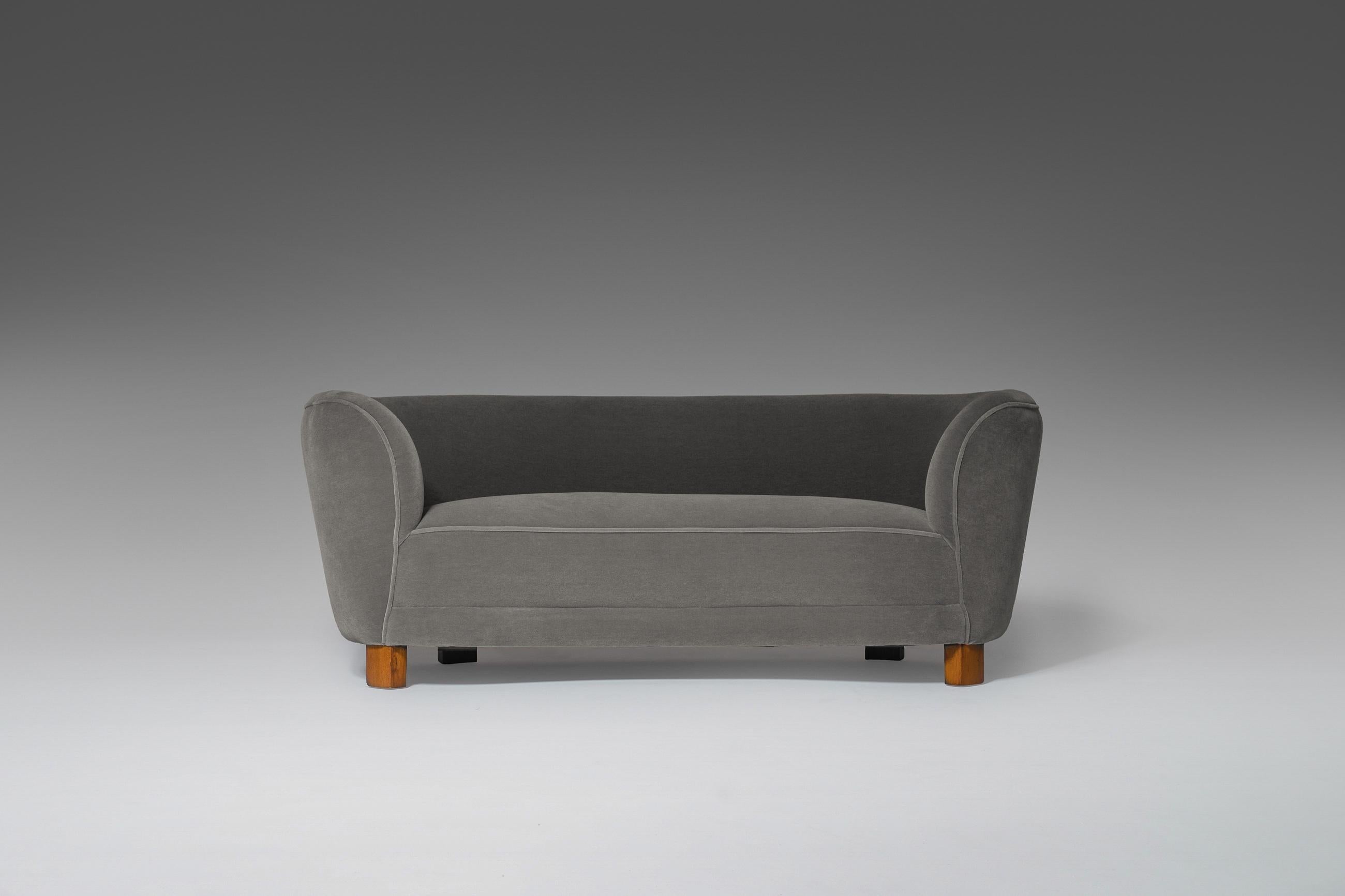 Elegantly curved sofa fabricated in Denmark, 1940s. The sofa is and slightly reshaped and reupholstered in a rich and modern mohair, which make the eccentric round puffy shapes stand out nicely while creating optimal comfort. The solid teak legs are