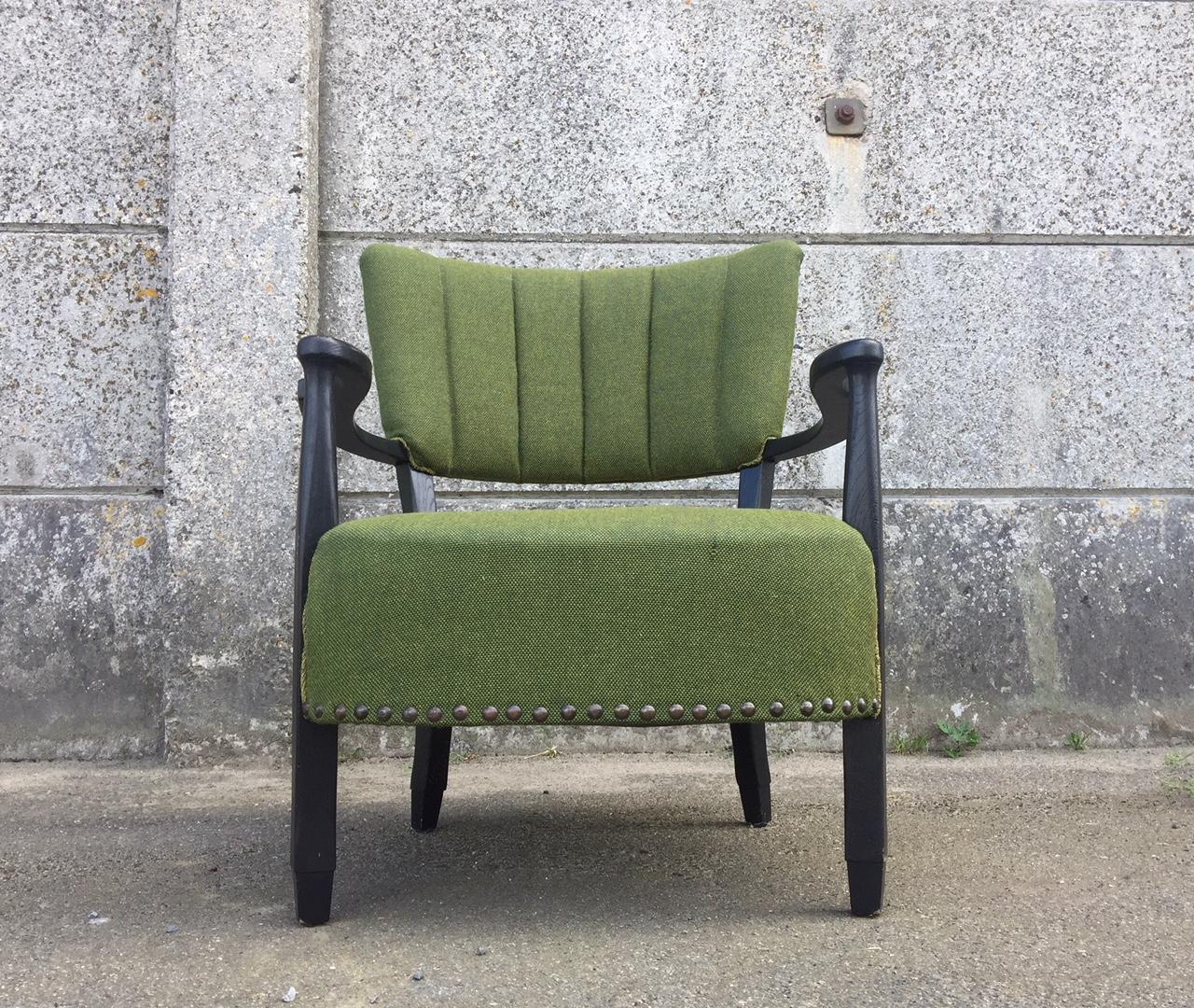 An easy chair by a Danish cabinetmaker. With a black painted wooden frame and a green wool riveted upholstery. A low-seat chair in a style reminiscent of Otto Schulz and Flemming Lassen.