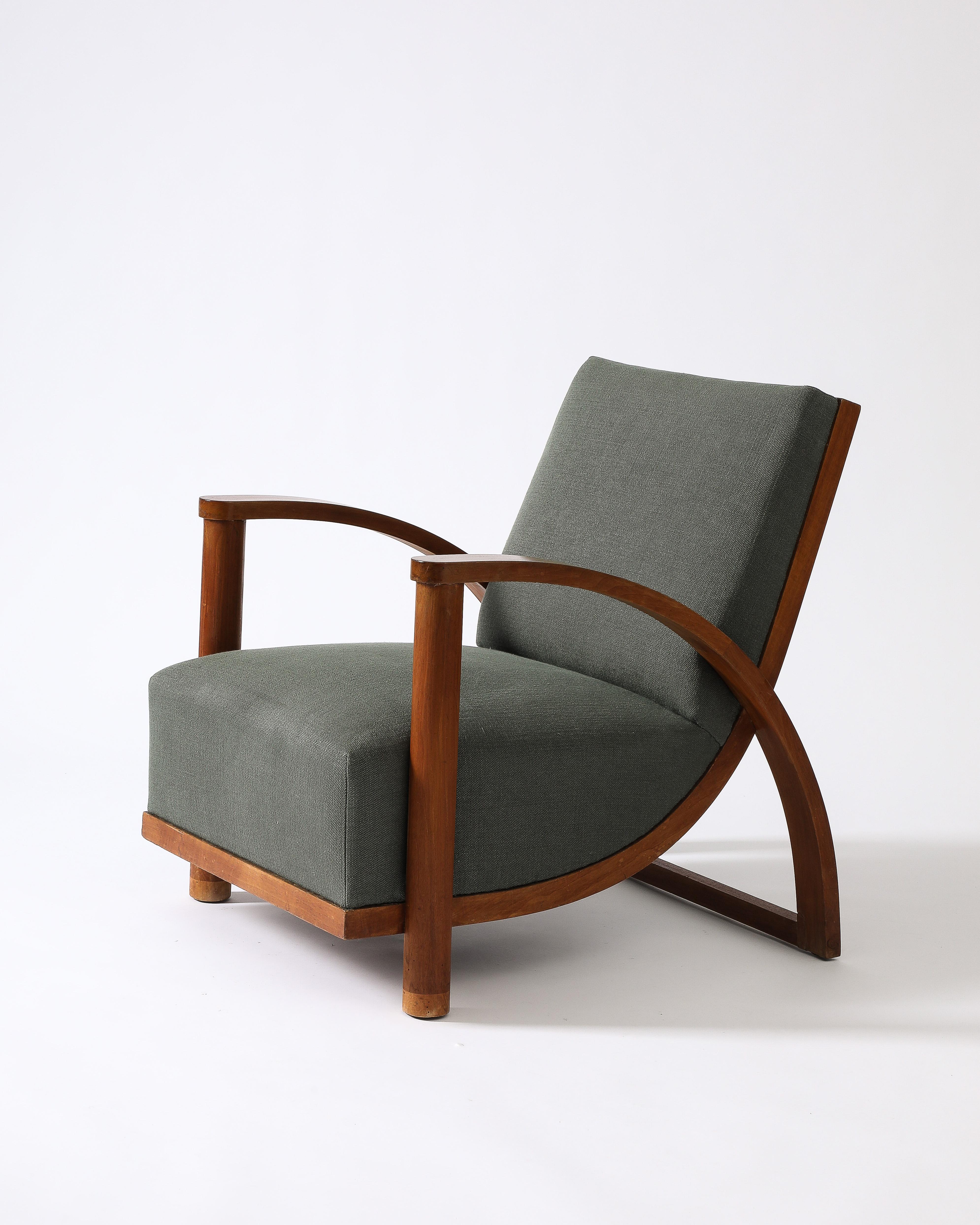 Sillón tapizado con reposabrazos curvados de olmo.

