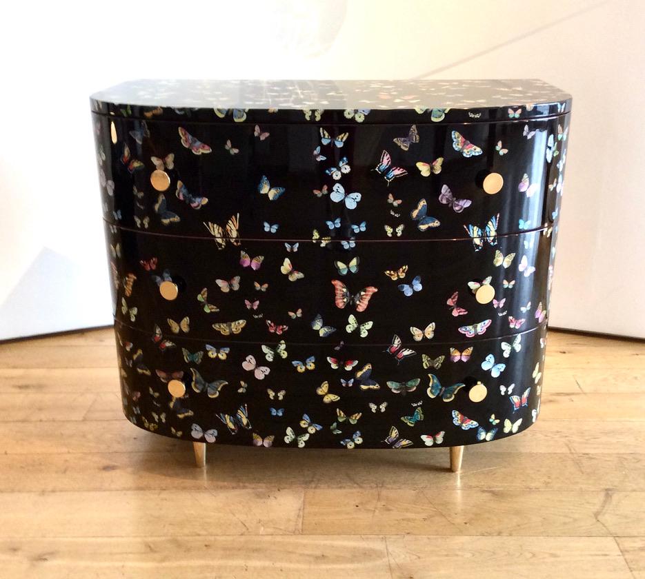 Sumptuous chest of 3 long drawers, with a silk-screened pattern of butterflies which have been hand-coloured by Fornasetti's artisans using traditional techniques, on black background, finished in high gloss lacquer.
With optional protective glass