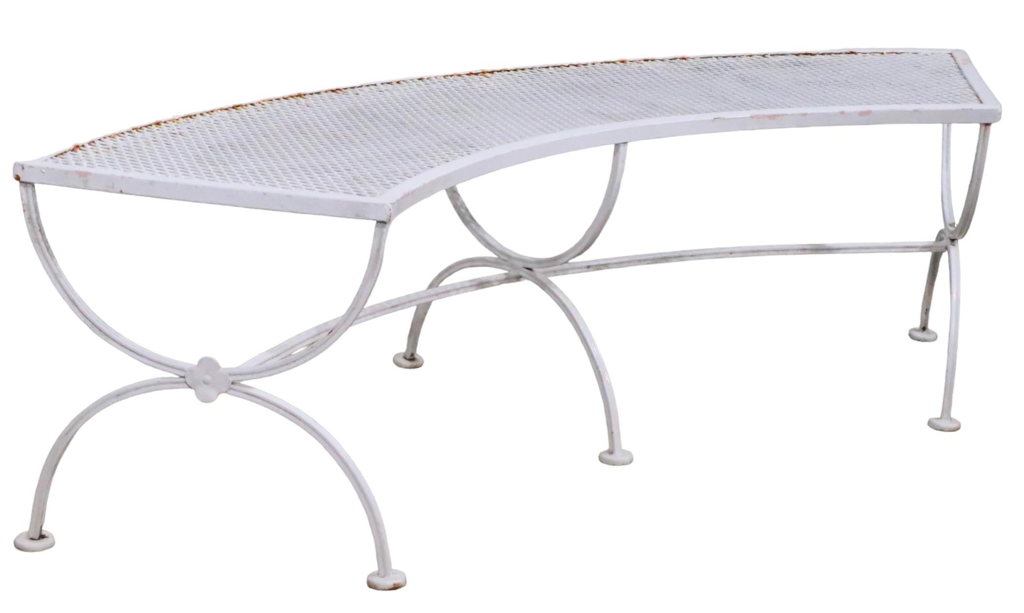 Curved wrought iron and metal mesh bench(s) by Salterini, three available. The benches feature U shaped legs, of wrought iron, which support the curved  metal mesh tops.  This desirable form is hard to find, especially hard to find in sets. Priced