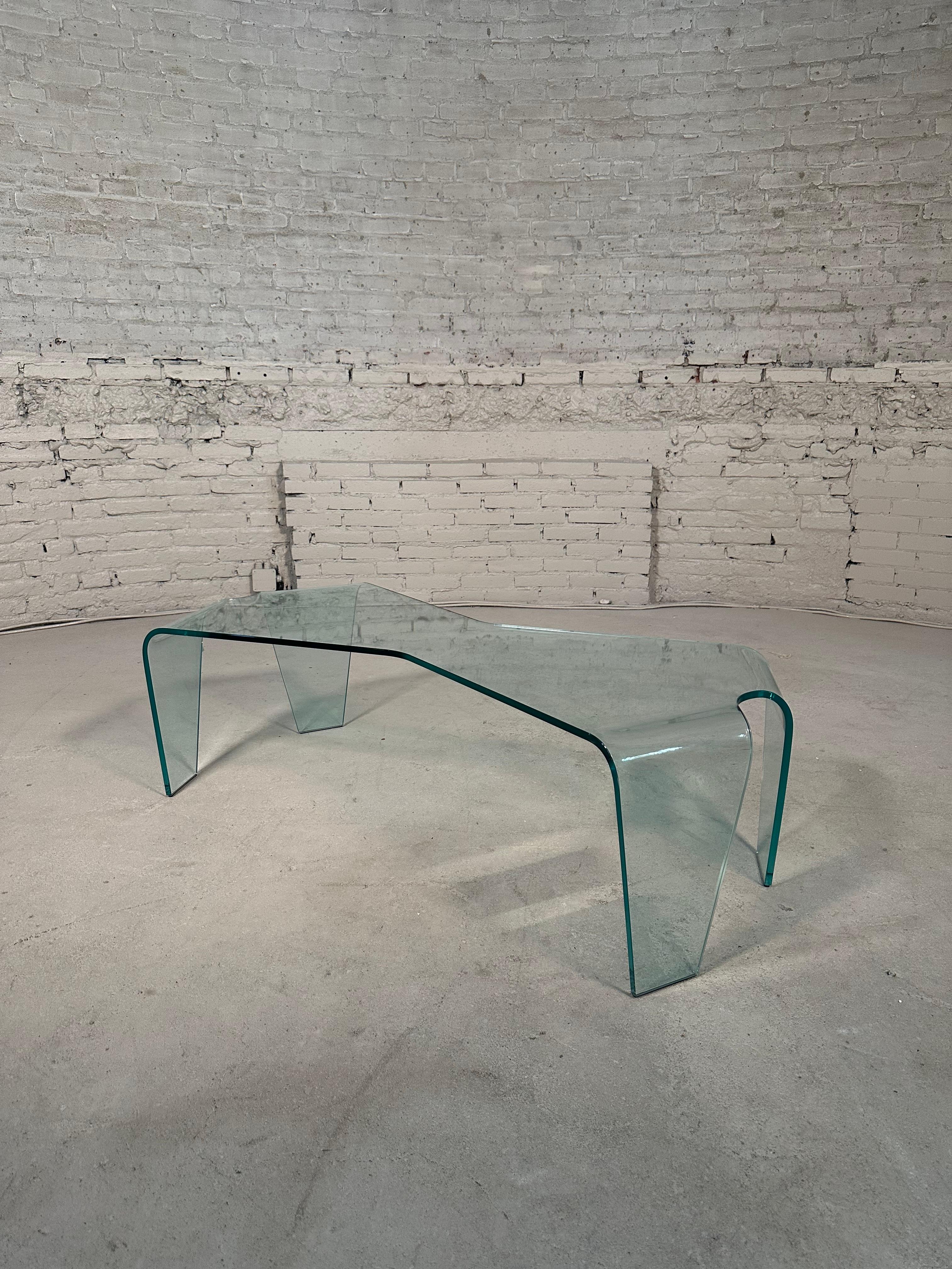 Elegant table made of curved glass. A timeless table that fits into all styles and rooms, providing space and visual light to the entire environment.