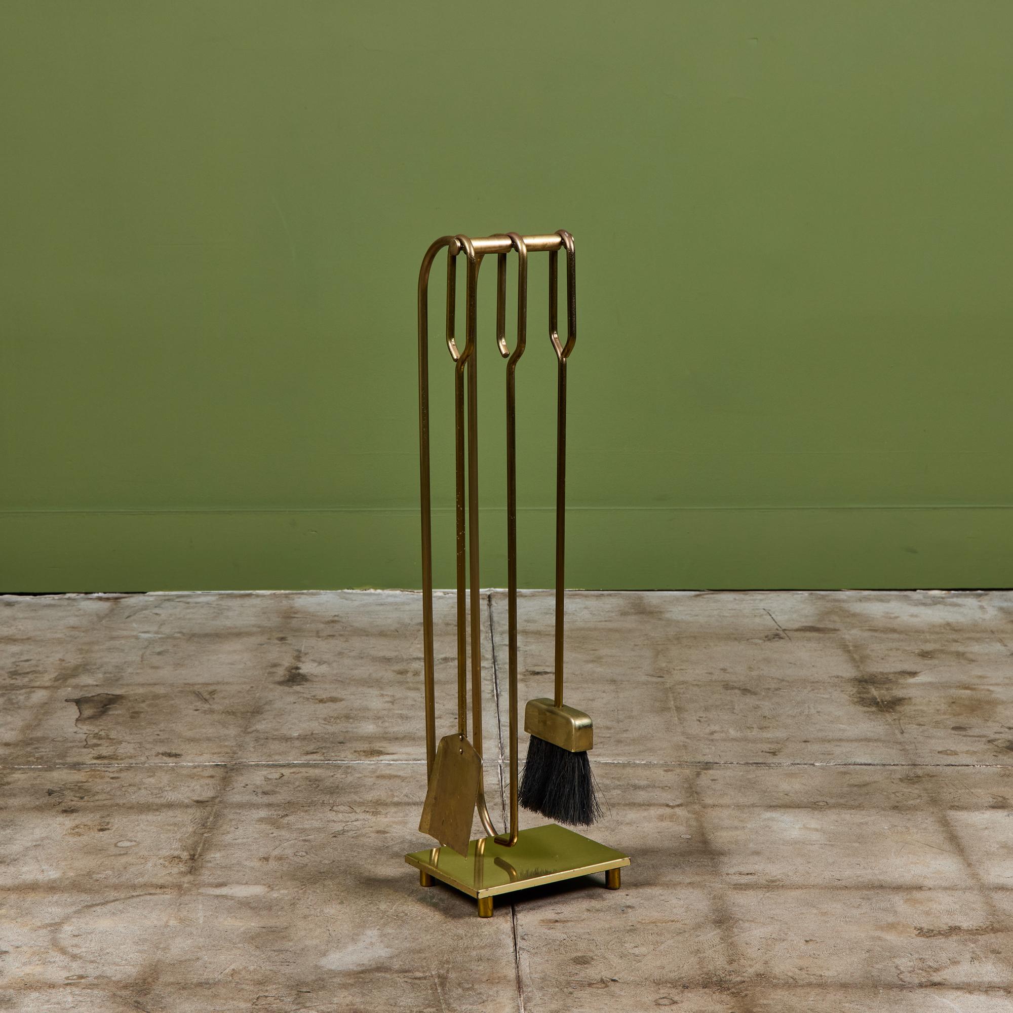 Three piece set of brass fireplace tools with stand. The set features three tools, shovel, broom and poker, with curved handles set on a matching brass stand. A perfect minimalist addition to your fireplace.

Dimensions
8.25