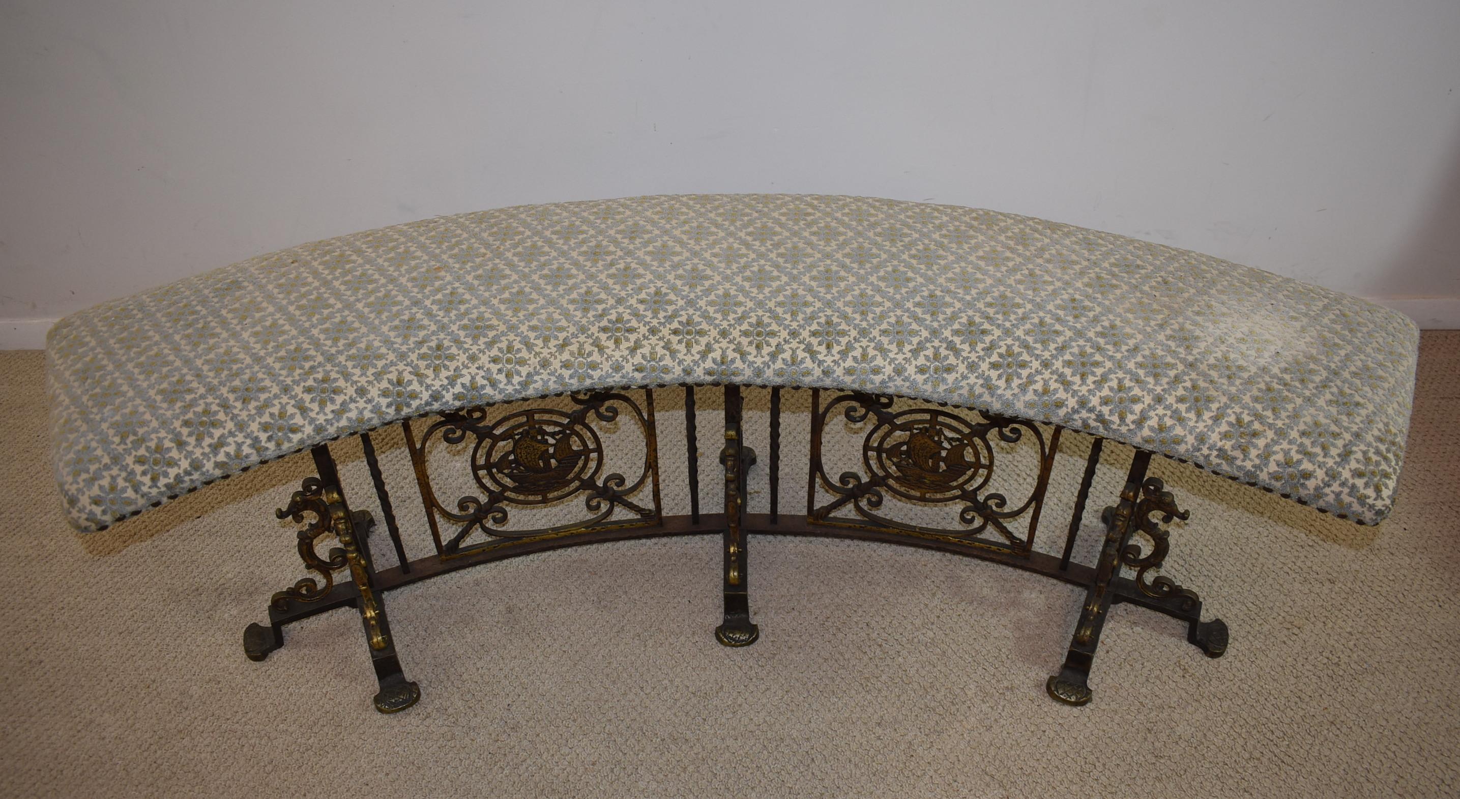 Unusual curved iron bench with upholstered seat and hammered finish. Brass ship and seahorse details. Original finish.