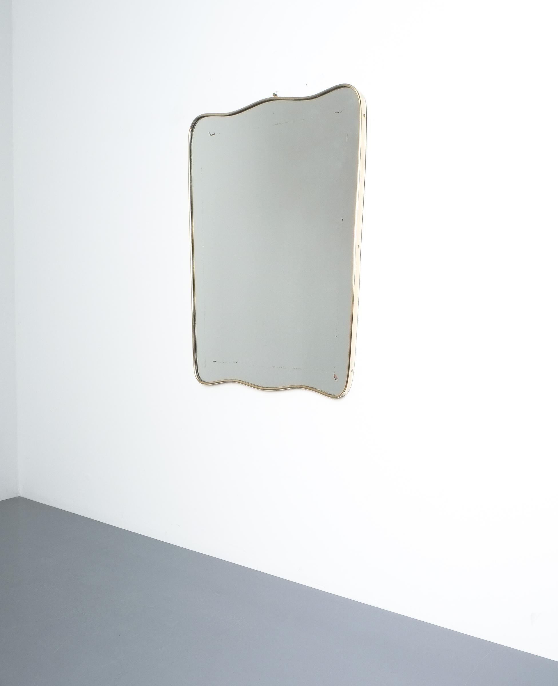 Curved Italian wall mirror minimal brass frame, Italy, circa 1955. Elegant and large wall mirror with a slender brass frame. Some staining on the mirror-glass (signs of aging) otherwise in good condition. Dimensions are 28.34