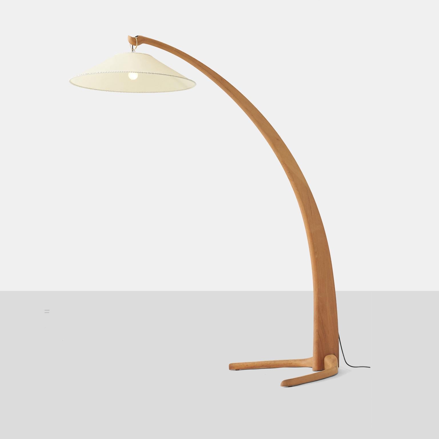 A beautiful Italian floor lamp with an arced walnut frame and paper shade suspended from a brass loop. Designed in the 1940s and produced in the 1980s.

Some very slight scratches and imperfections to the wood. Some imperfections and marks on the