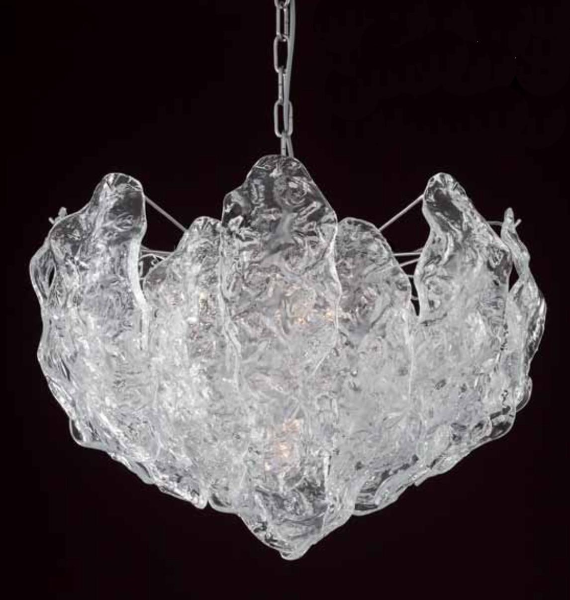 Italienischer Kronleuchter mit klaren, gebogenen, strukturierten Murano-Glasblättern, die an einem verchromten Metallrahmen hängen / inspiriert von Mazzega, hergestellt in Italien
4 Leuchten / Typ E26 oder E27 / je max. 60W
Maße: Durchmesser 20 Zoll