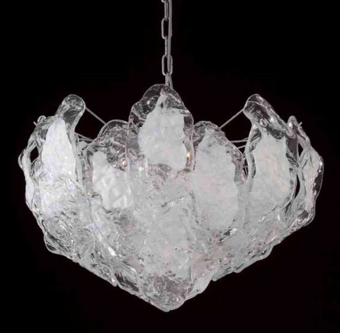 Italienischer Kronleuchter mit gebogenen Blättern aus klarem und milchig weißem Murano-Glas, die an einem verchromten Metallrahmen hängen / inspiriert von Mazzega, hergestellt in Italien
4 Leuchten / Typ E26 oder E27 / je max. 60W
Maße: Durchmesser