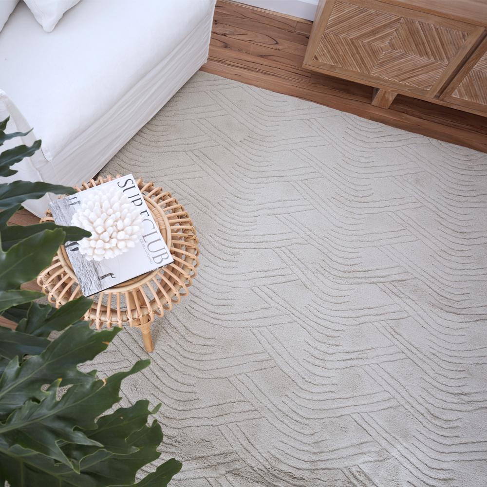 The voyage weave features a curved undulating line pattern, reminiscent of dunes and sand Formations. This subtle etched style is expertly hand-loomed in a deep pile of pure wool, with a Classic tonal palette of fresh cream and dusty dove