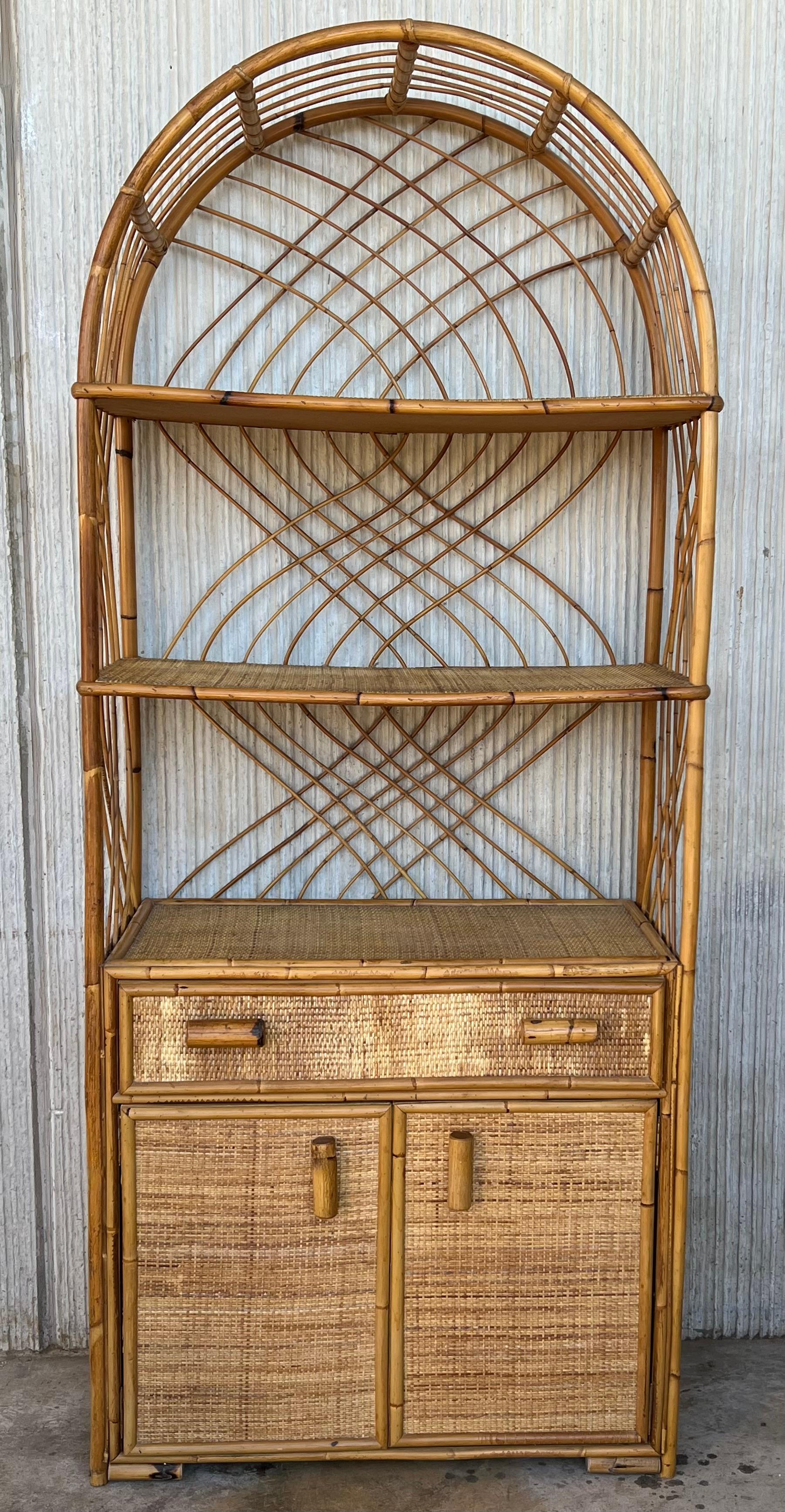 Beautiful bookcase from the 1970s. The bookcase has three shelves and at the bottom has two drawers and two doors with original bamboo knobs and two more shelves inside. 

