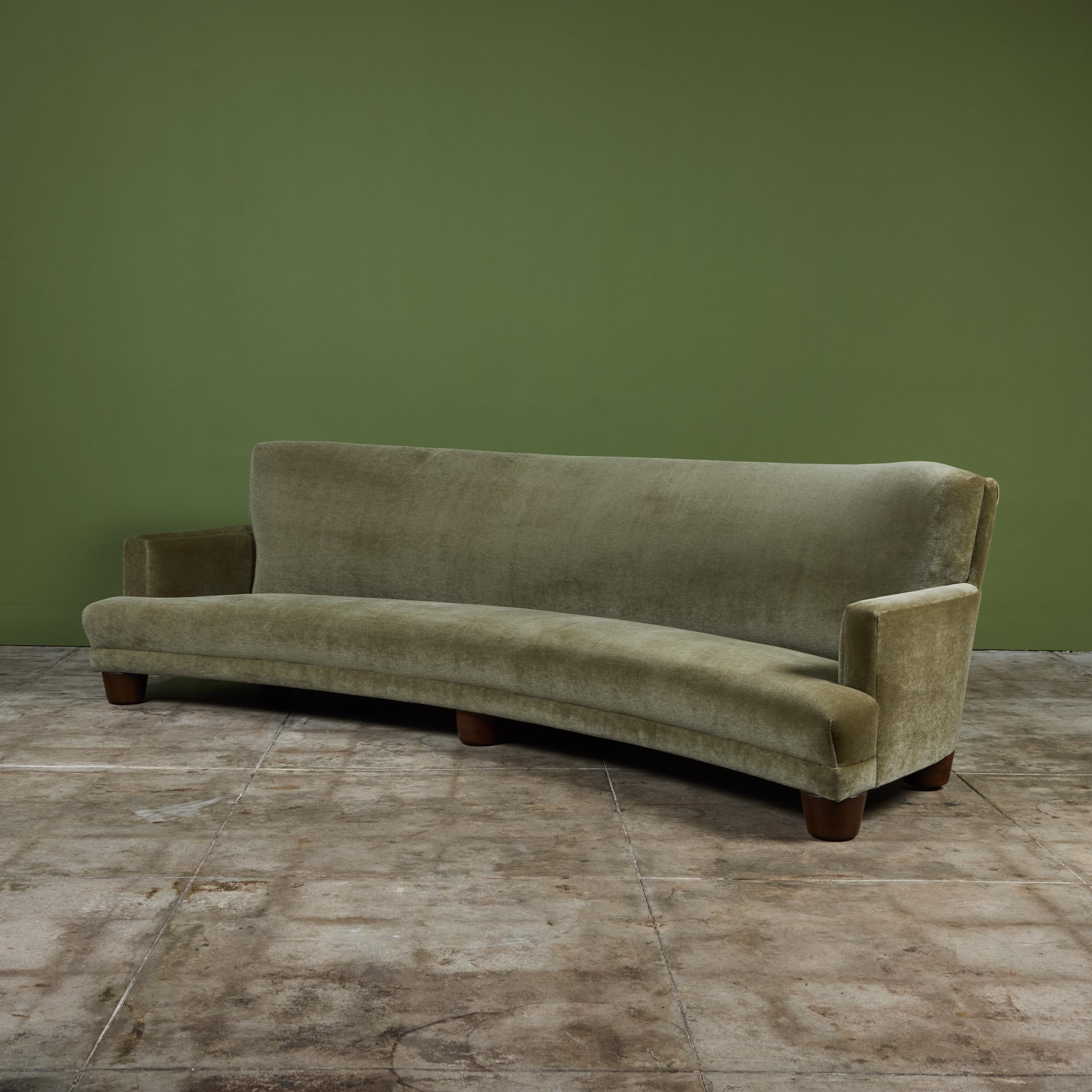 Large curved sofa inspired by Italian mid-century design. Its sensuous curves and sleek shape makes it a statement piece in any interior. Newly upholstered in a beautiful sage green mohair velvet. The deep seating along with the comfortable rounded
