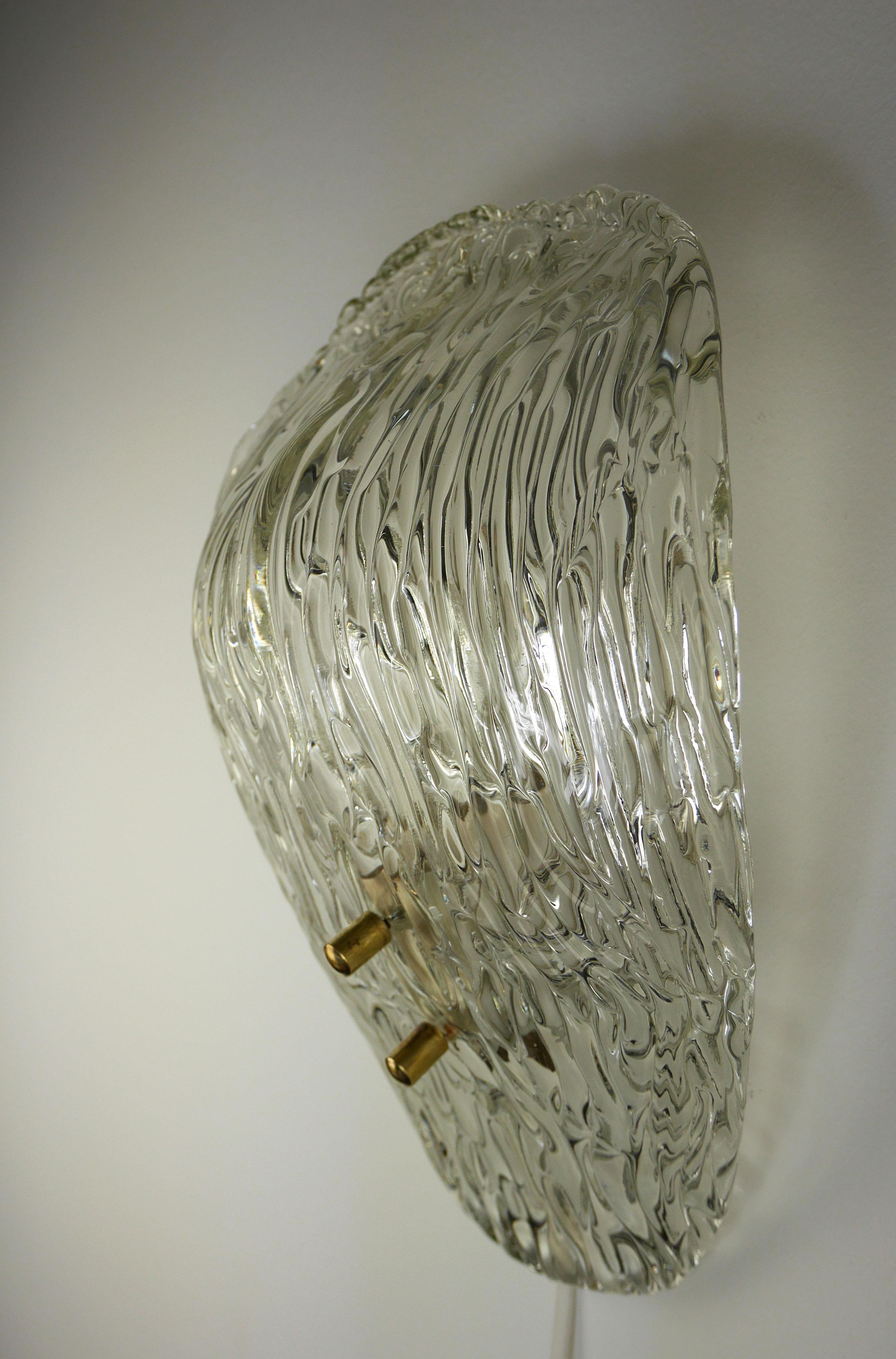 Stunning European Mid-Century Modern wall light designed and produced by Austrian designer Julius Theodor Kalmar in the 1950s. Curved shape of clear and ice textured Italian Murano glass. Brass hardware and metal mount. Excellent vintage