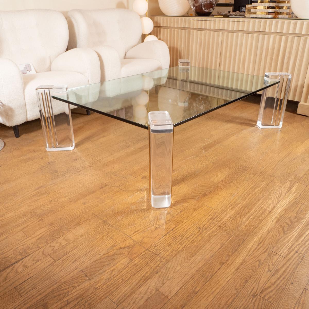 Rectangular glass coffee table with lucite and brass supports. 