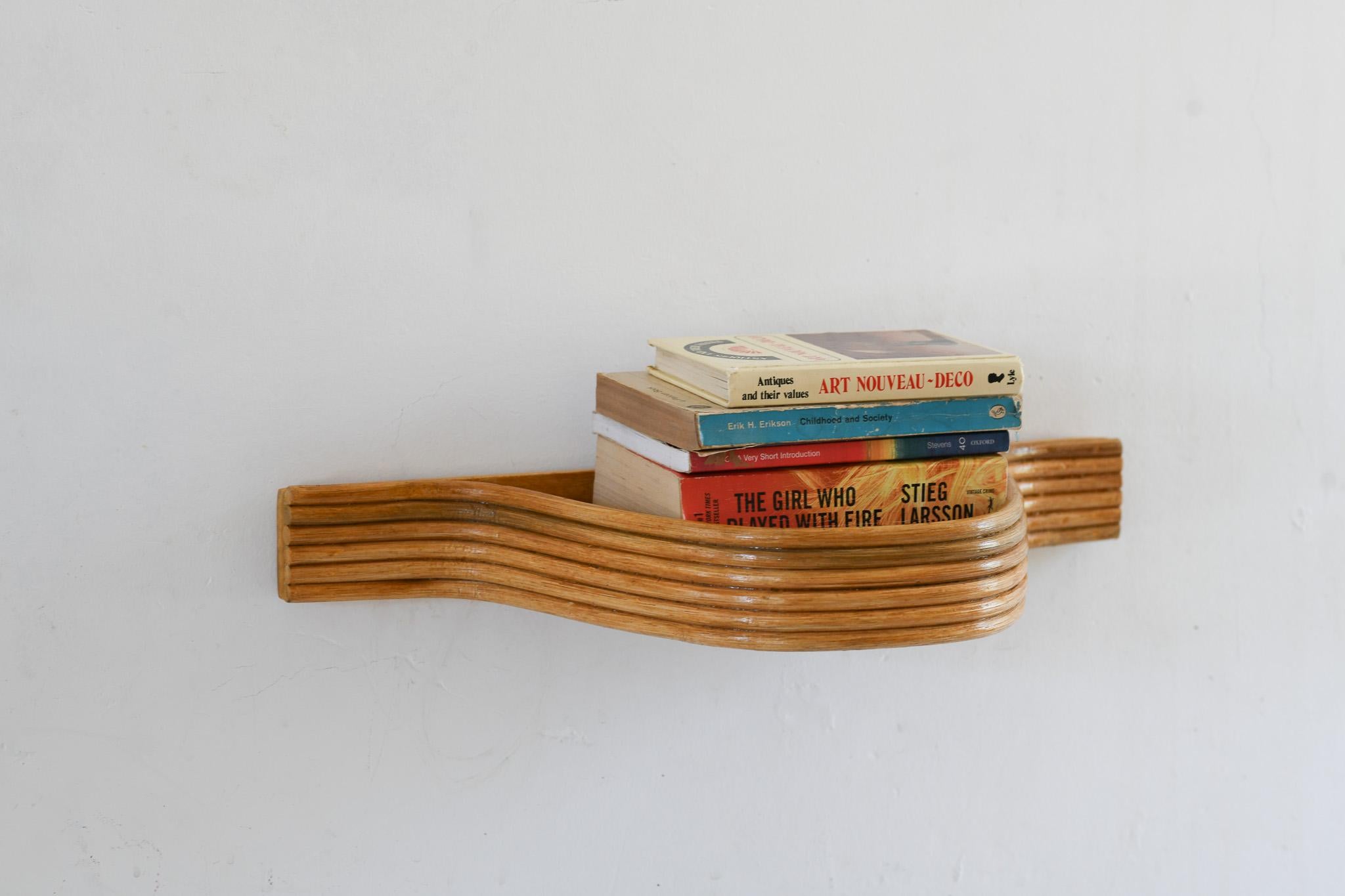 Verschönern Sie Ihren Raum mit der einzigartigen Ästhetik dieses geschwungenen Schweberegals aus Pencil Reed Rattan. Dieses aus natürlichen Materialien gefertigte Regal strahlt Qualität und Langlebigkeit aus. Sein geschwungenes Design verleiht jedem
