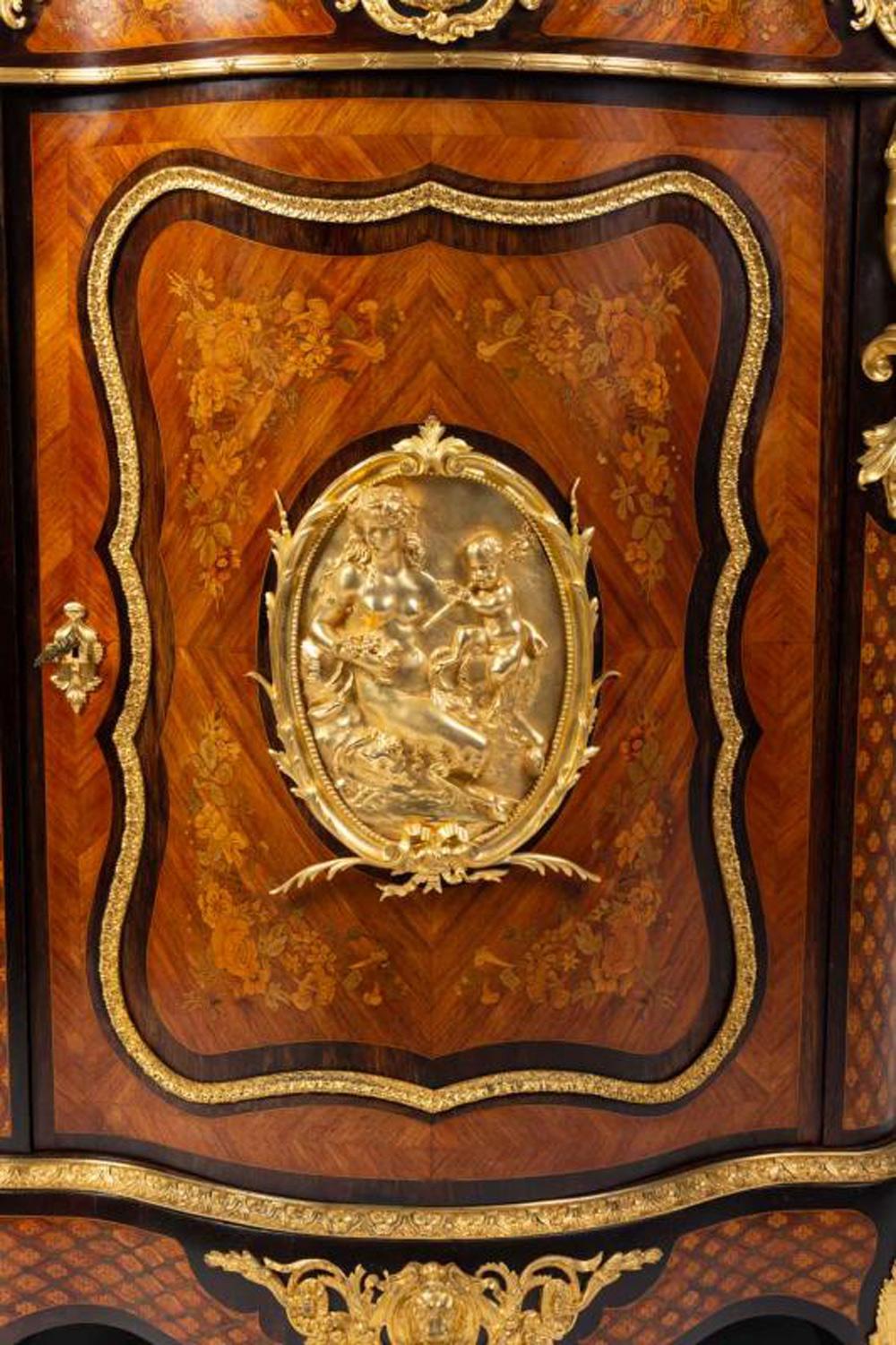 Curved cabinet in rosewood veneer and marquetry of several wood species with a marble top, Napoleon III period. High quality cabinet making. A gilded bronze medallion decorates the central door and a beautiful ornamentation of gilded bronzes enrich