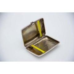 Curved silver case with engravings around monogram card