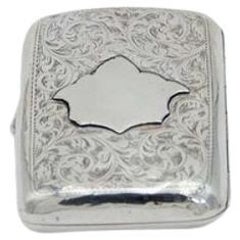 Curved silver case with engravings around monogram card