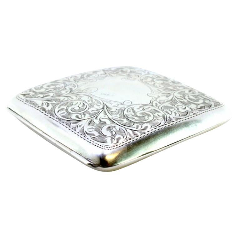 Curved silver case with plant motifs around monogram and gold interior