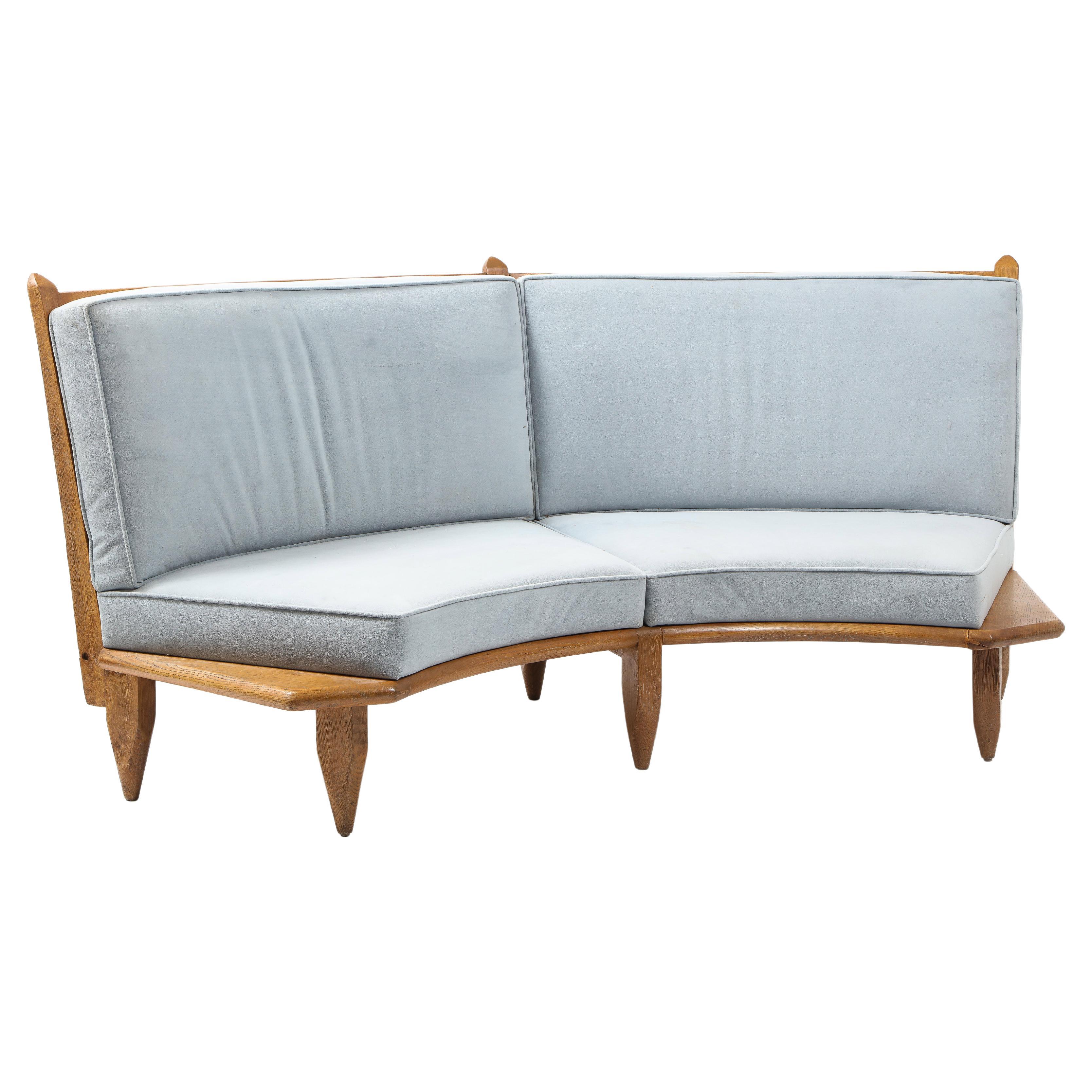 Unusual oak sofa by Guillerme & Chambron for Votre Maison. The frame has the usual hallmarks of their production with the extended end and thick pencil-shaped legs with a curved back and vertical dowels holding the cushion. In great conditions with