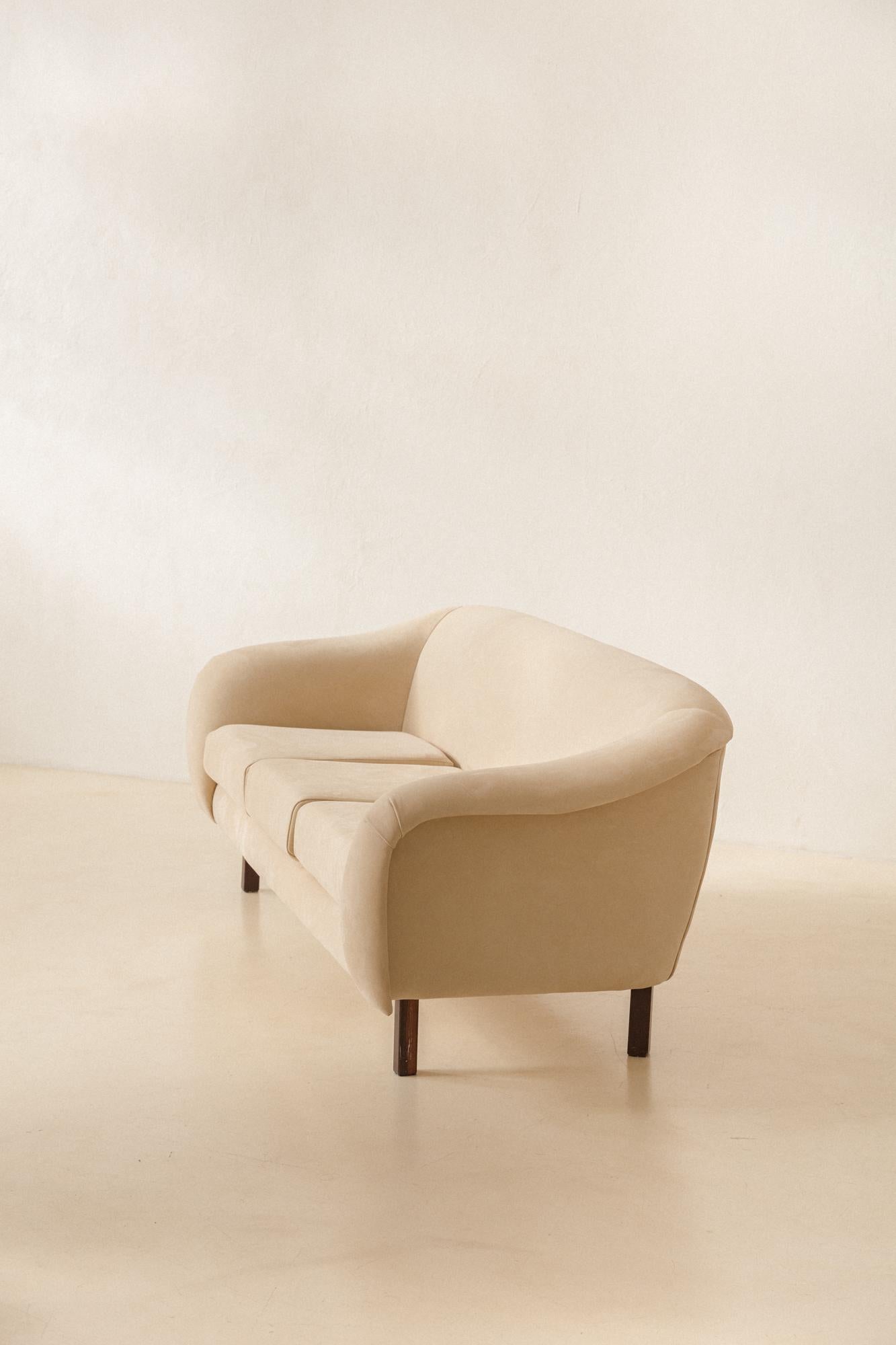 Joaquim Tenreiro (1906-1992) entwarf und produzierte das geschwungene Sofa um 1960 und vermarktete es in seinem Unternehmen Tenreiro Móveis e Decorações - mit Geschäften in São Paulo und Rio de Janeiro.

Der Holzrahmen besteht aus einem