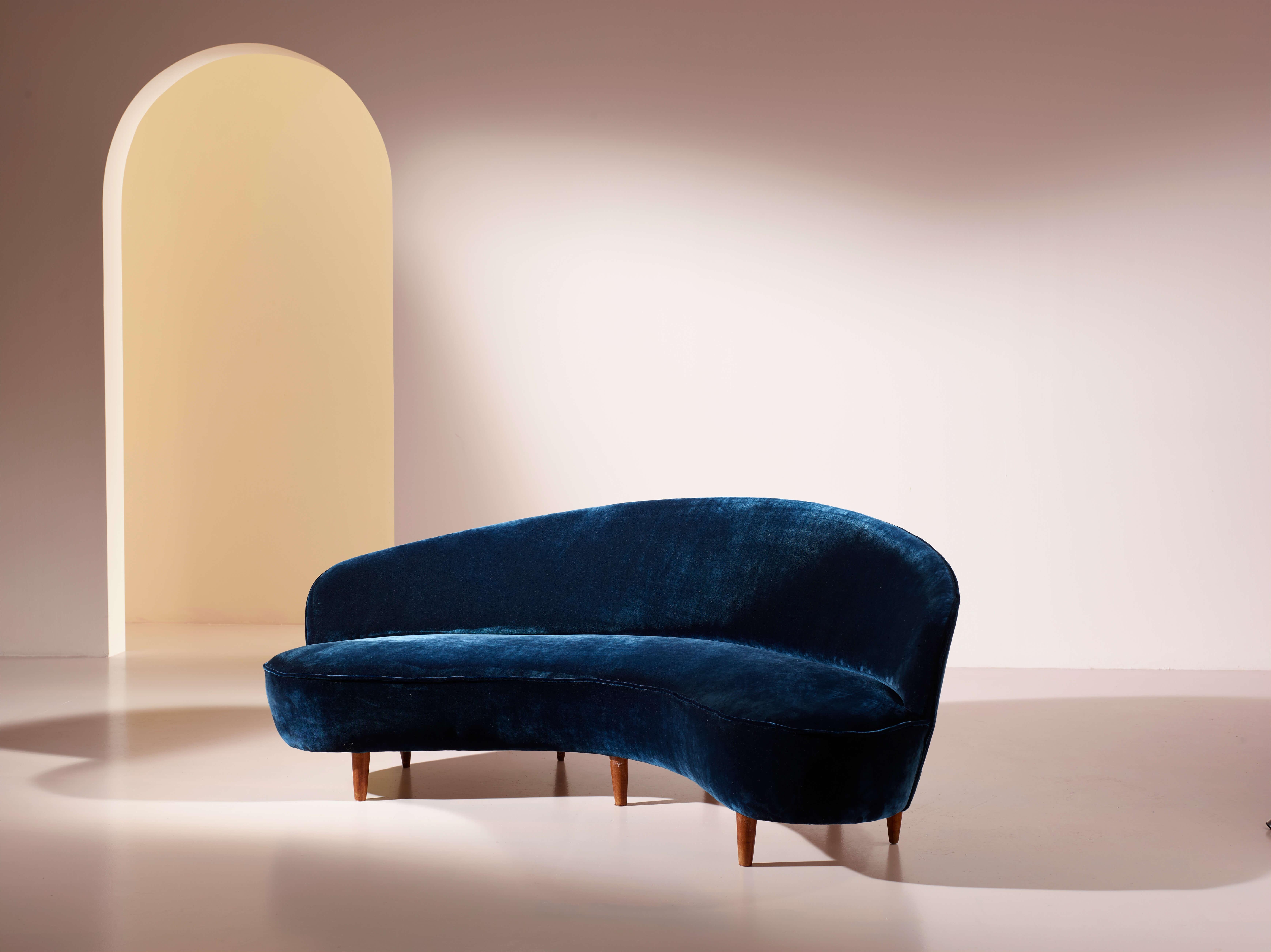 A curved sofa in wood and fabric, velvet upholstery, Italian craftsmanship, in the style of Gio Ponti, 1950s.

Comfort demands curved lines, and this Italian sofa perfectly meets the needs of the modern home, where aesthetics and comfort must