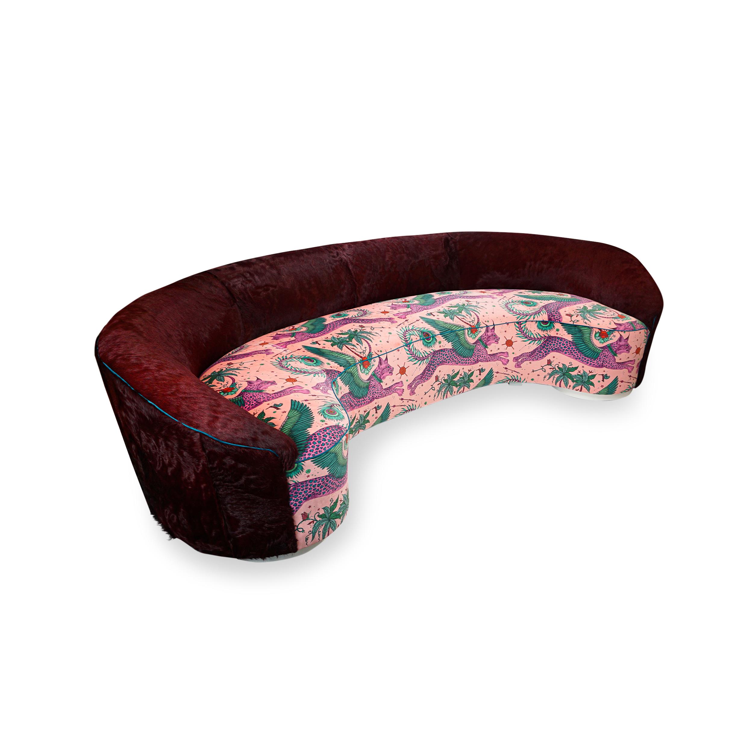 Curved, symmetrical sofa with slop arms upholstered with oxblood color hair on hide on back and fantastical printed velvet on seat with contrast welting. Grotesque and outrageous, exceptional and beautiful in one piece. Frame is hard maple and