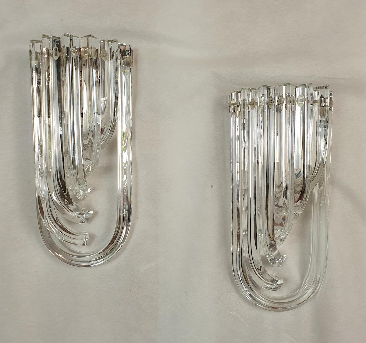 Pair of curved unusual Murano glass wall sconces, by Venini Italy, 1980s.
Two pairs available; priced and sold by pair.
The Mid-Century Modern pair is made of curved hand blown clear Murano glass Triedri, on a chrome frame.
A timeless design,