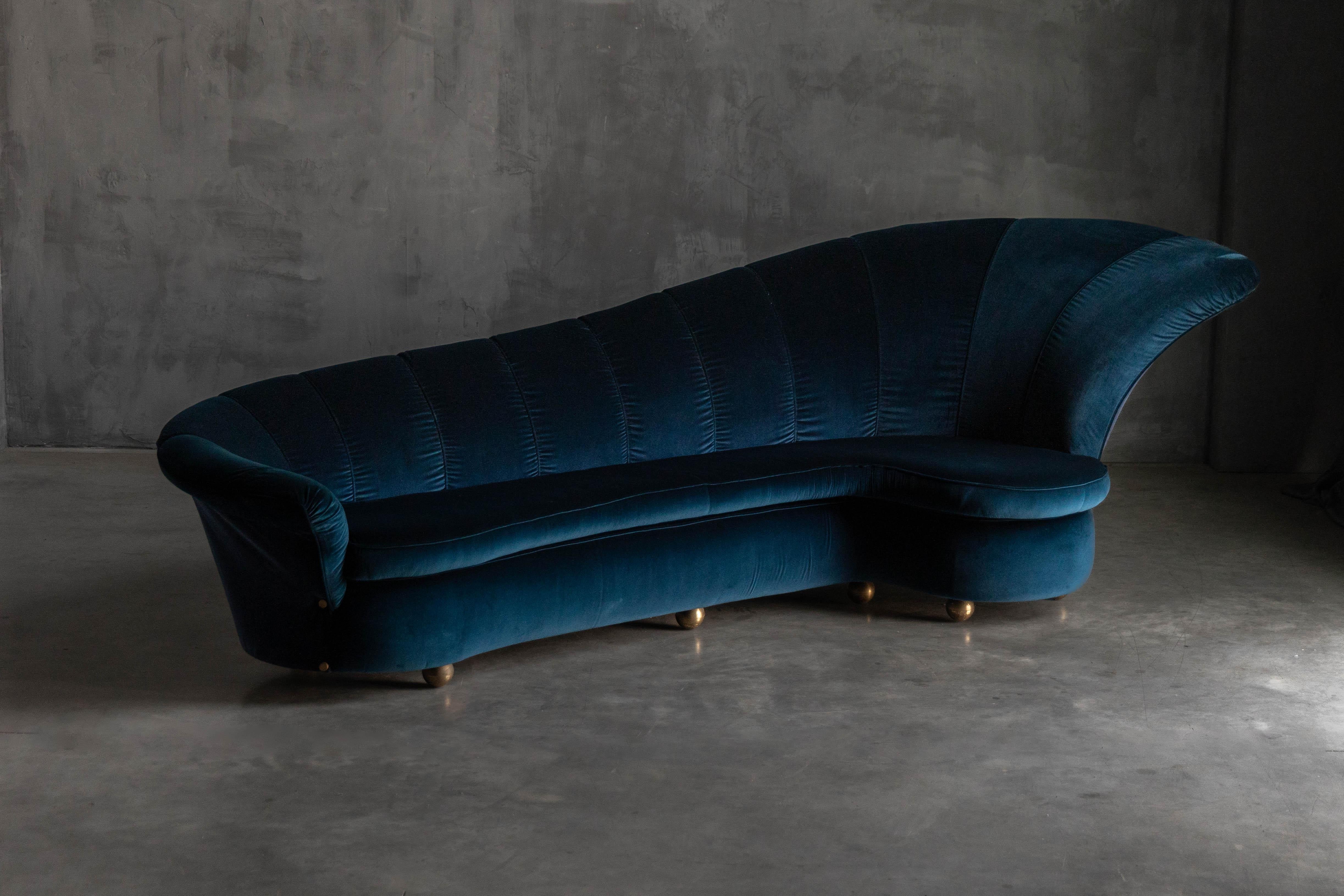 Italian glam couch in luxurious blue velvet, attributed to Marzio Cecchi. A striking detail is the round brass feet, which complement the deep, elegant tones of the velvet. The piece reflects Cecchi’s design philosophy as a renowned architect from