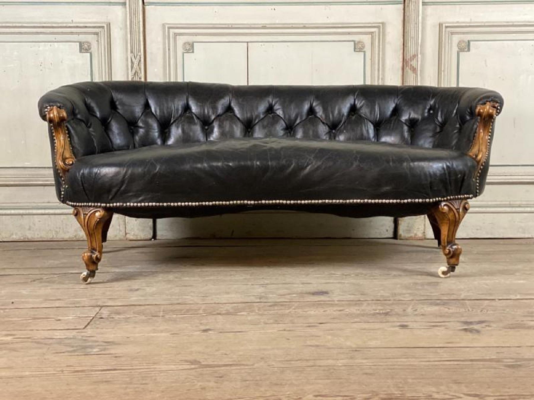 Curved Victorian sofa, carved walnut and leather.