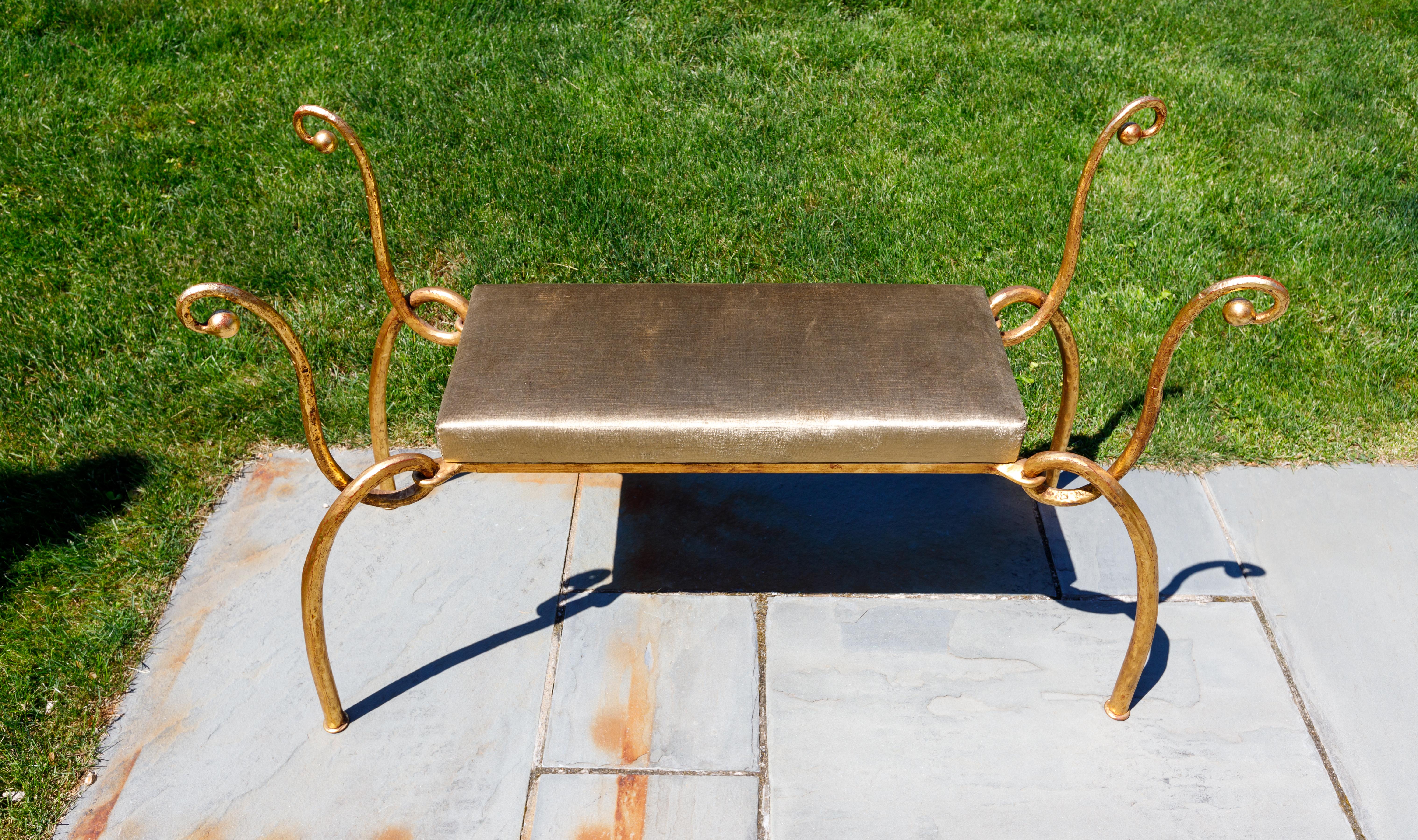 Curvilinear gilt iron bench with upholstered seat.