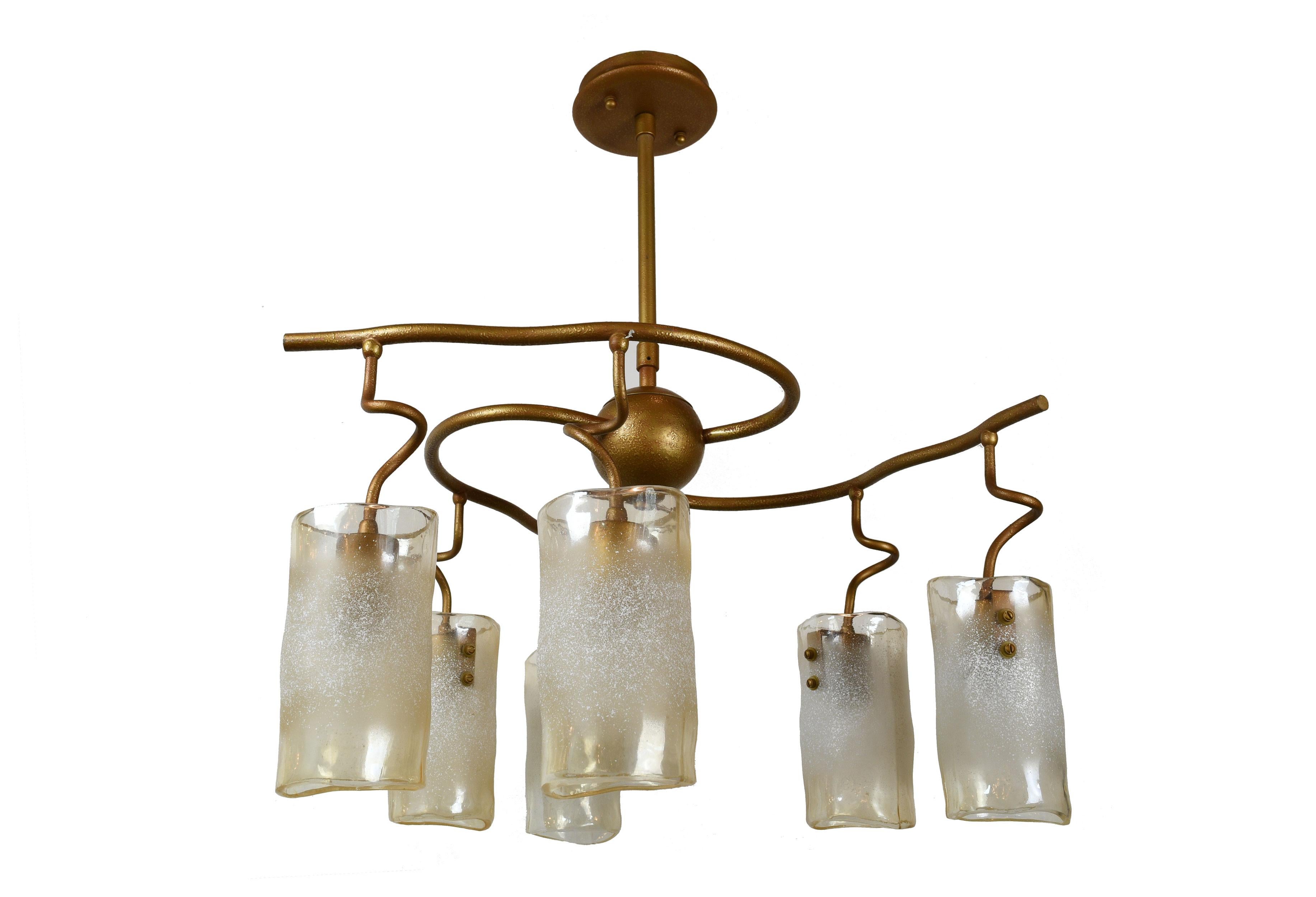 This organic fixture features 3 curvilinear arms swirling, reaching out from a central golden orb. Each arm holds two white speckled and cylindrical shades. This simple fixture is given life in the spirals of the arms and the palpable flow of the