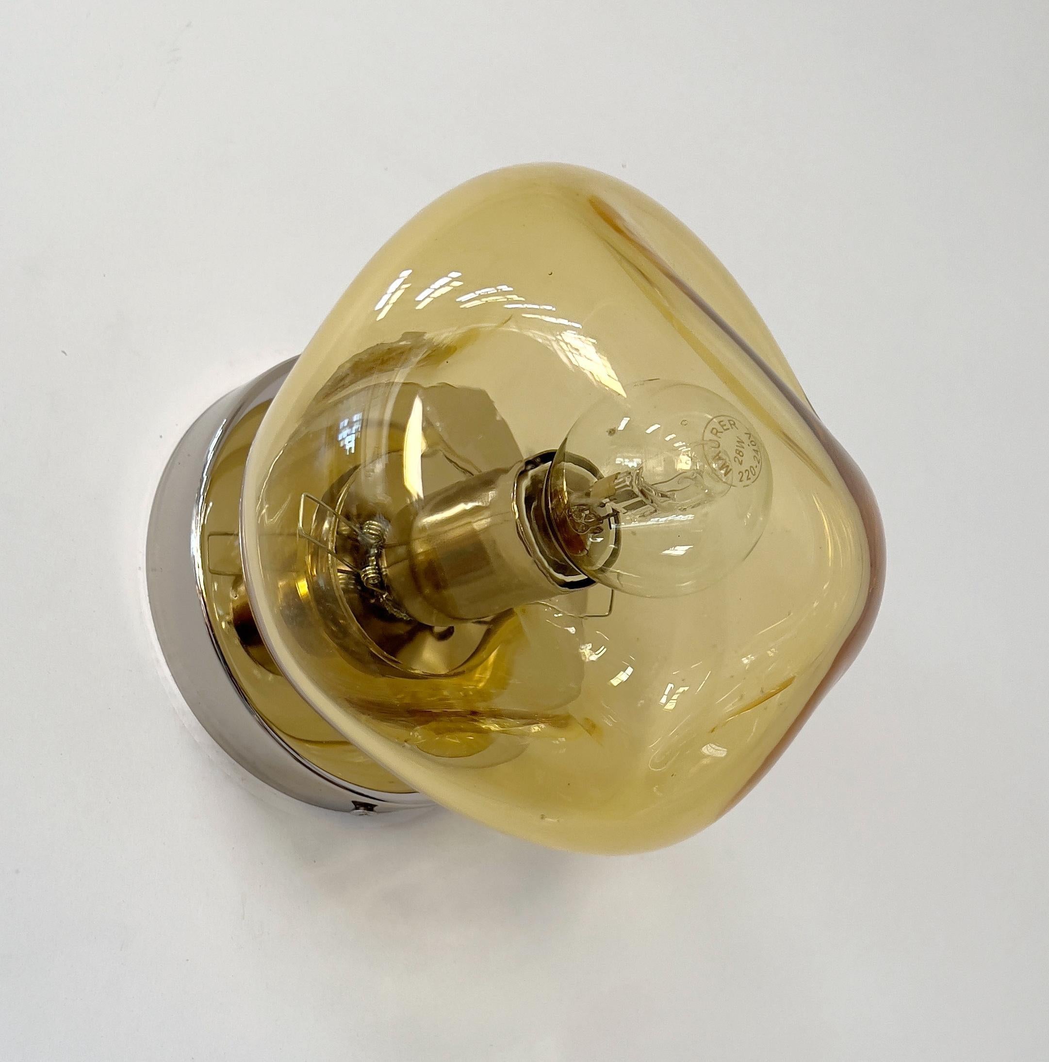 Aplique o empotrable moderno italiano con pantalla de cristal de Murano alabeado color ámbar, montado sobre una estructura de metal acabado en níquel pulido, diseñado por Fabio Bergomi para Fabio Ltd, fabricado en Italia.
1 luz / tipo E12 o E14 /