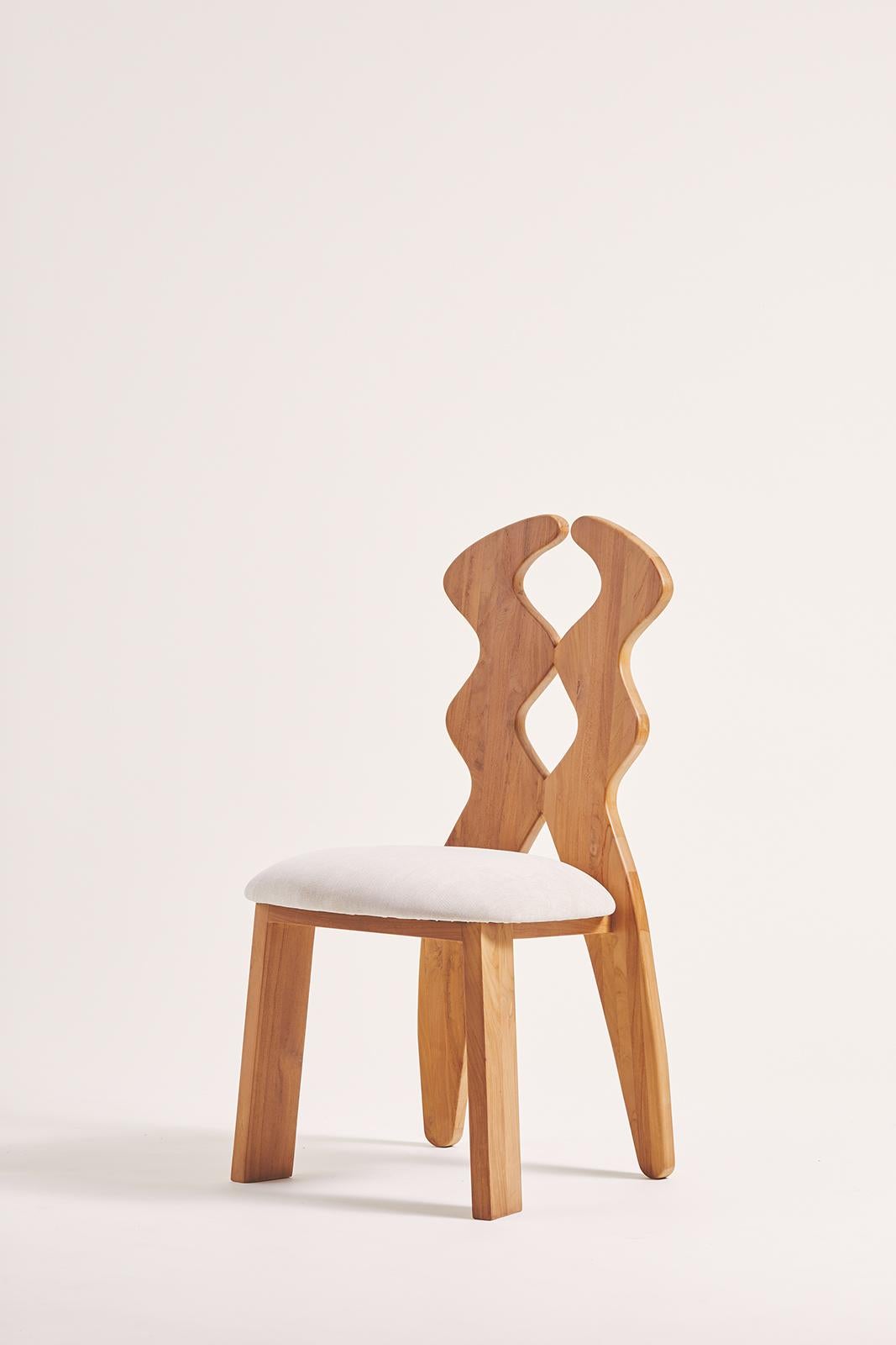 The Curvy Dining Chair features an organic geometric shape on the back, crafted from two solid pieces of wood hand-sculpted to perfection. Designed to be timeless, it merges contemporary design with a refined aesthetic. Its fluid lines and elegant