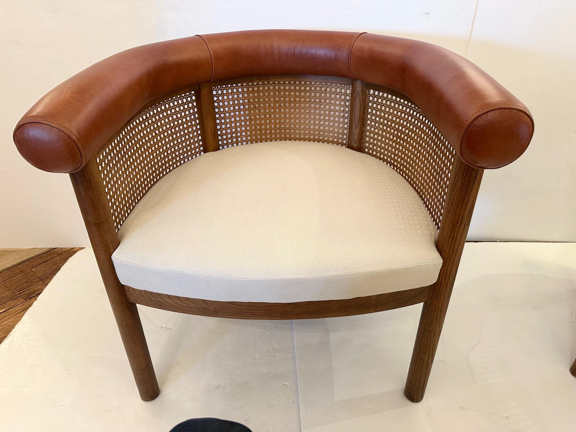 Chic pair of club chairs having a stylish combination of caned bodies, upholstered seats and leather wrapped tops to the backs.
Seat: 16.5” H x 21” D
Arm 27” H
