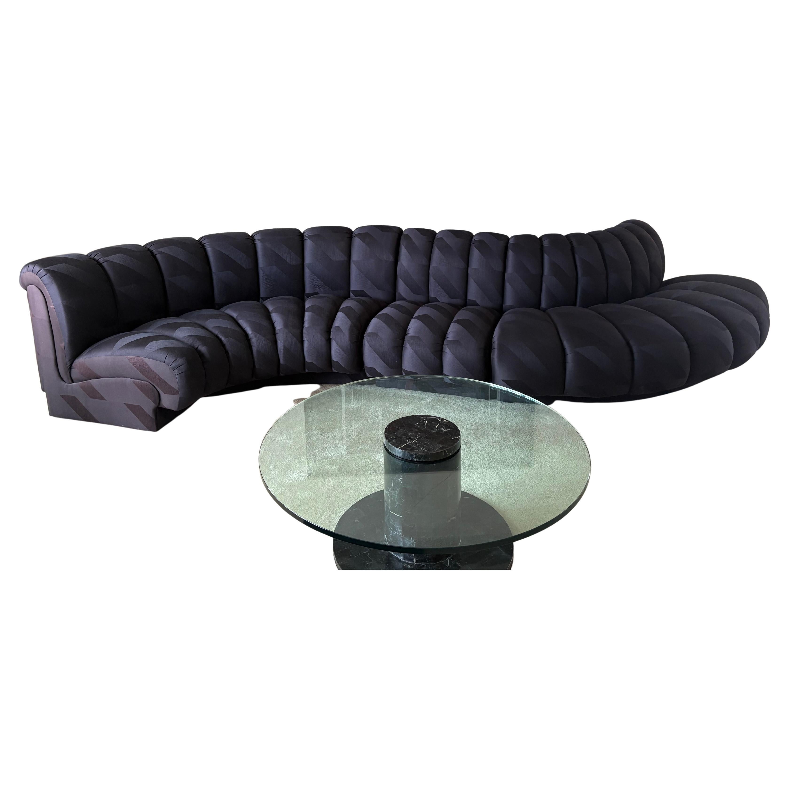 Frappant et sculptural canapé sectionnel serpentin à dossier rembourré, 3 pièces, ayant un tissu de mélange de coton et de rayonne noir sur noir.  Très confortable.
Section la plus large à gauche 
78w (dos) 36 d 30 h
Profondeur d'assise 23-24