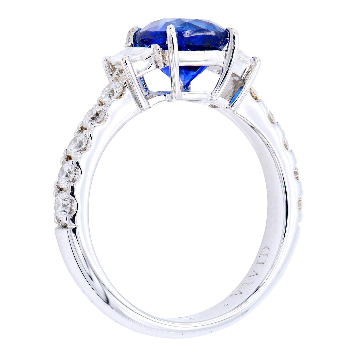 This Ceylon 2.18 carat royal blue sapphire is set with 2 diamond trapezoids totaling 0.20 carats on either side followed by 10 more round diamonds on the band totaling 0.43 carats. This gorgeous ring is set in 4.5 grams of 18 karat white gold and is