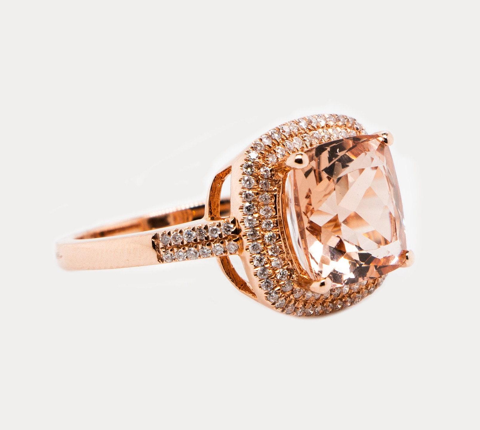 This is a gorgeous natural 4.40carat morganite and diamond ring set in solid 14K Rose Gold. The natural 10MM cushion cut morganite (AAA quality gem) has an excellent peachy pink color and is surrounded by a double halo of round cut white diamonds.