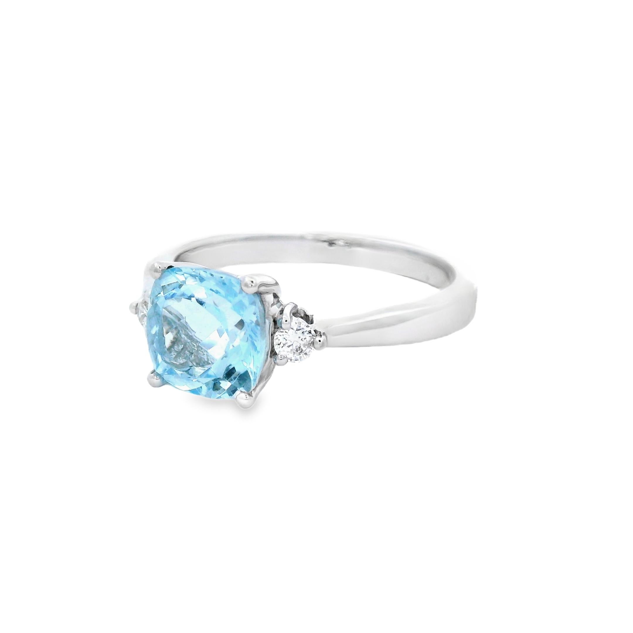 Fresh and refined, this three-stone ring features a 7mm cushion-cut aquamarine weighing 1.35 carats, flanked by two sparkling diamonds and set in polished 14K white gold. The aquamarine’s airy blue hue is clean and vivid, offering a cool and calming
