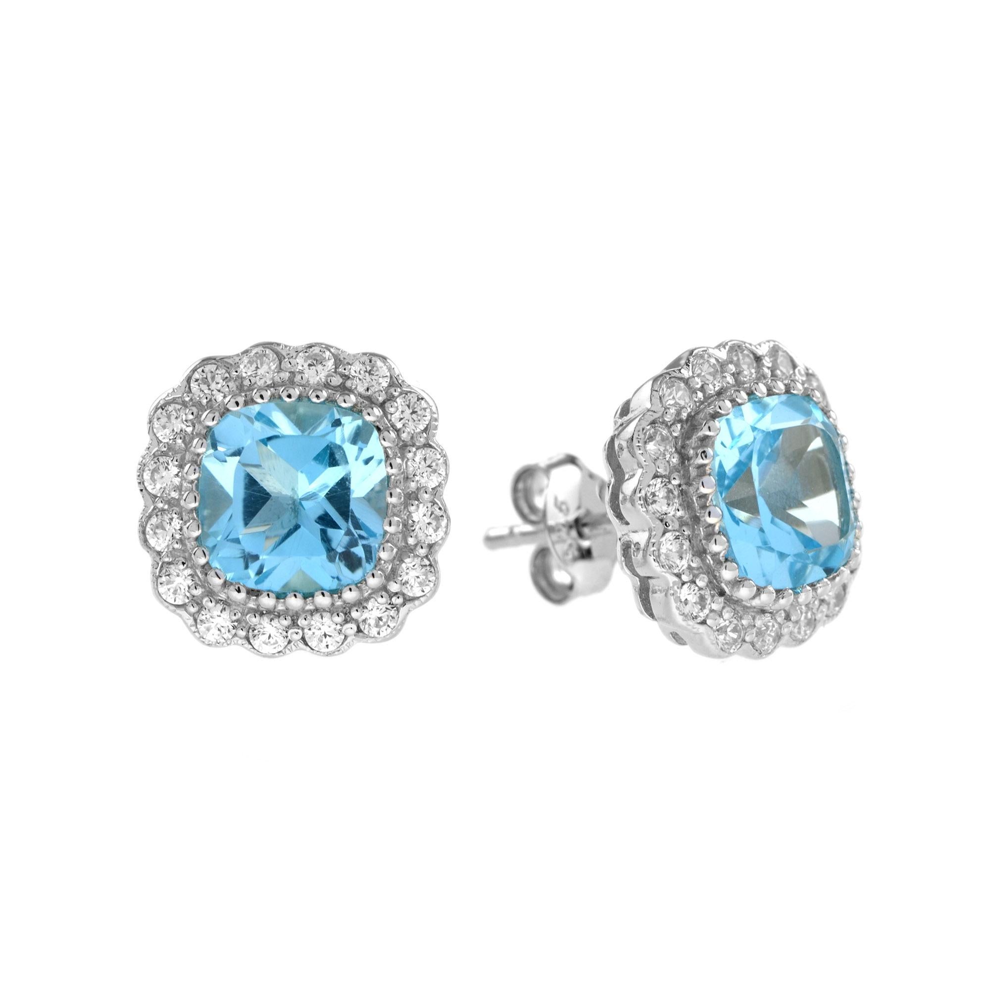 Ces magnifiques boucles d'oreilles et ce pendentif en or blanc 14k sont ornés d'une topaze bleue coussin de 5,70 carats.  entouré d'un halo de diamants. Une mise à jour sans effort de votre garde-robe d'accessoires. Portez-les ensemble pour un look