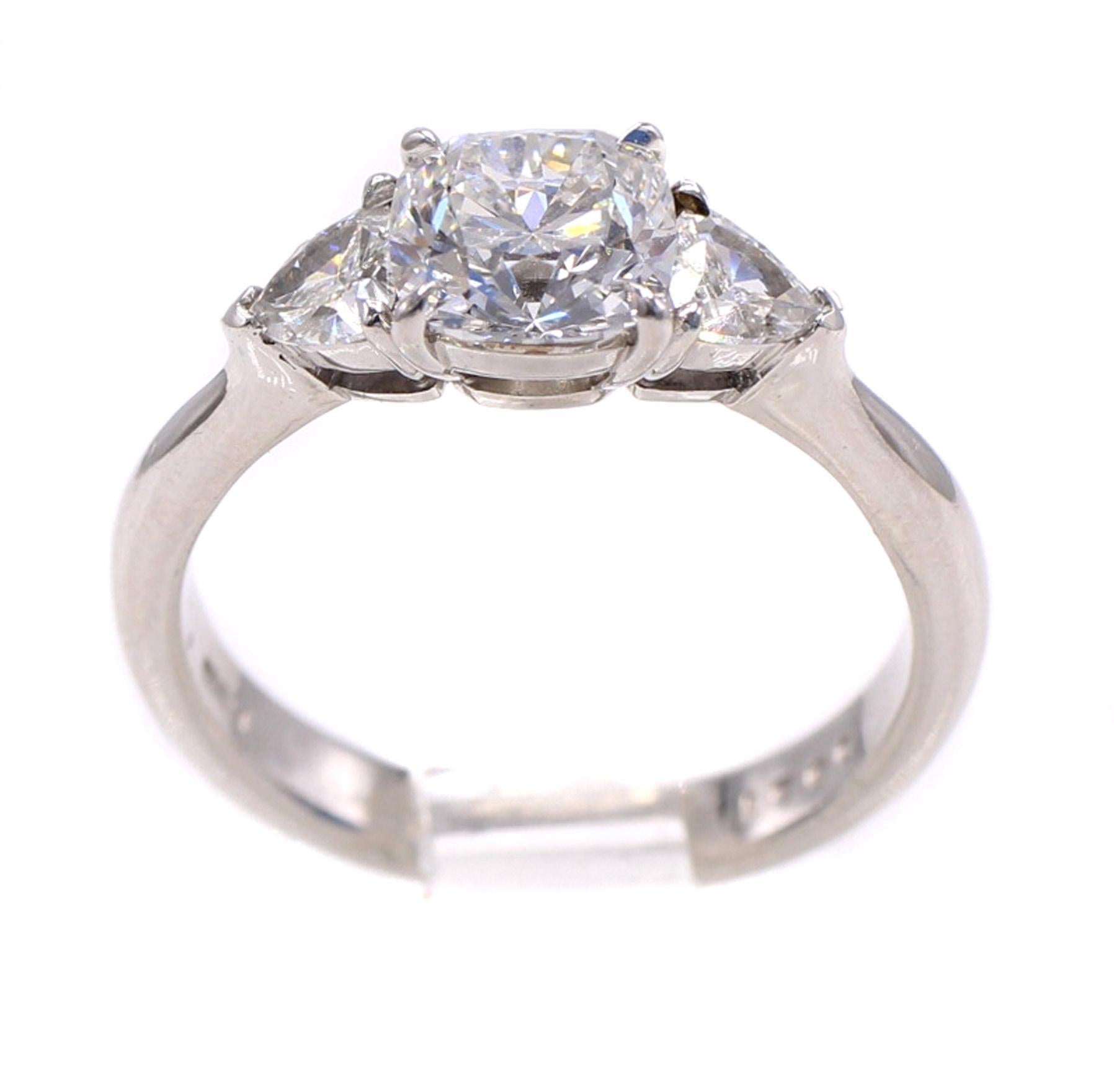 A beautifully cut bright and lively cushion brilliant weighing 1.12 carats is the centerpiece of this wonderfully handcrafted platinum engagement ring. The cushion is accompanied by a report from the GIA grading the color as E and the clarity as
