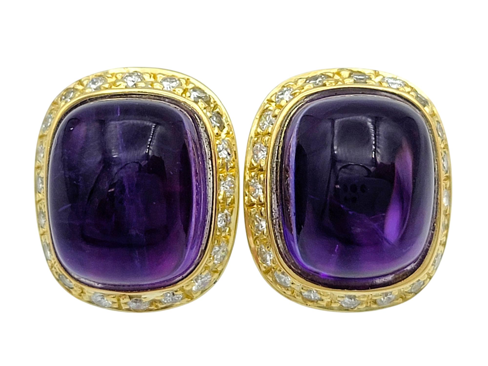 Ces boucles d'oreilles remarquables présentent une paire d'améthystes coussin de couleur pourpre, serties dans de l'or jaune 18 carats. Les surfaces lisses et bombées des améthystes mettent en valeur leur teinte naturelle profonde et leur caractère