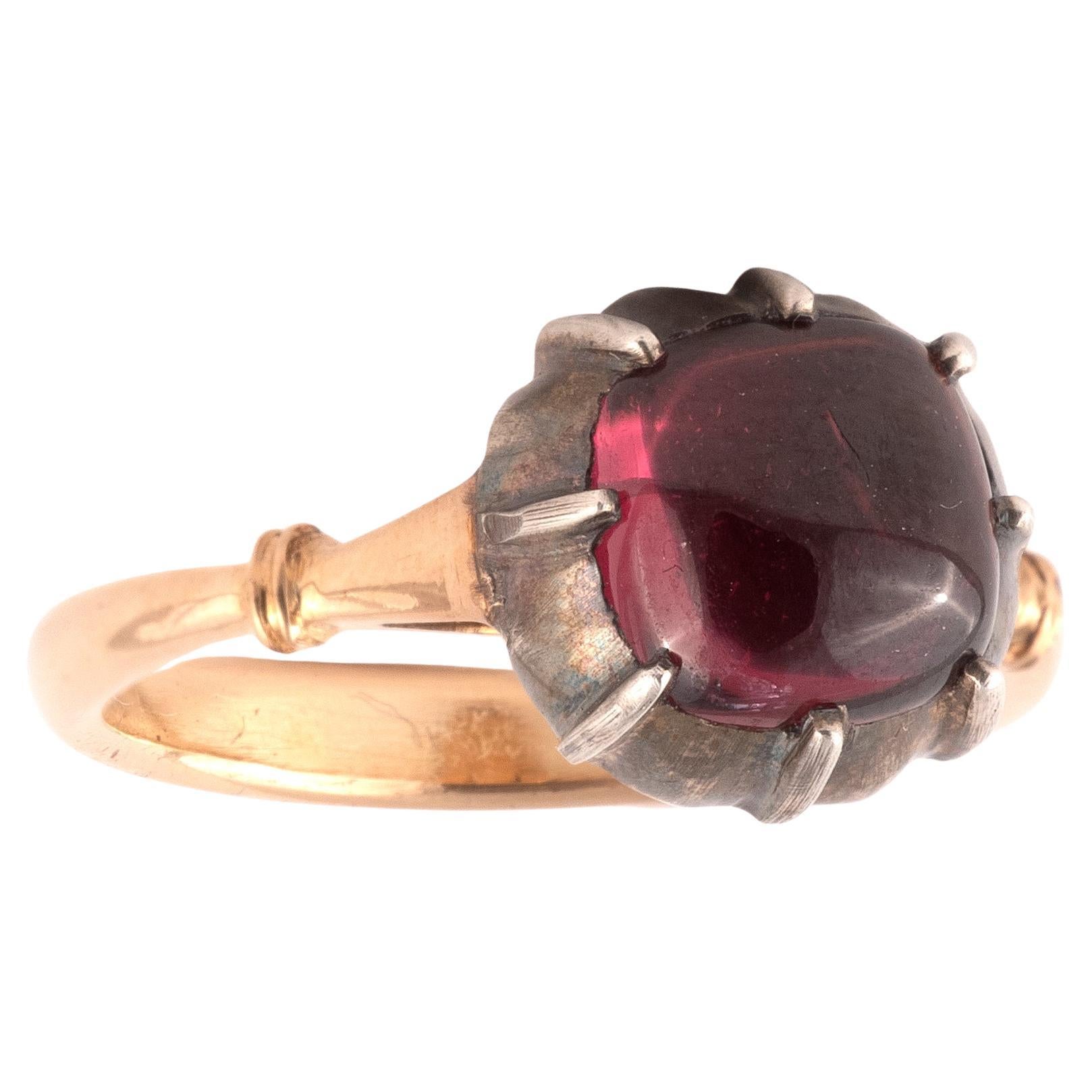 Un grenat cabochon est au centre de la monture, de style géorgien, en argent noir sur or jaune 18ct, avec un anneau arrondi en or jaune 18ct. 
Taille : 7 1/2
Poids : 4,98gr.
